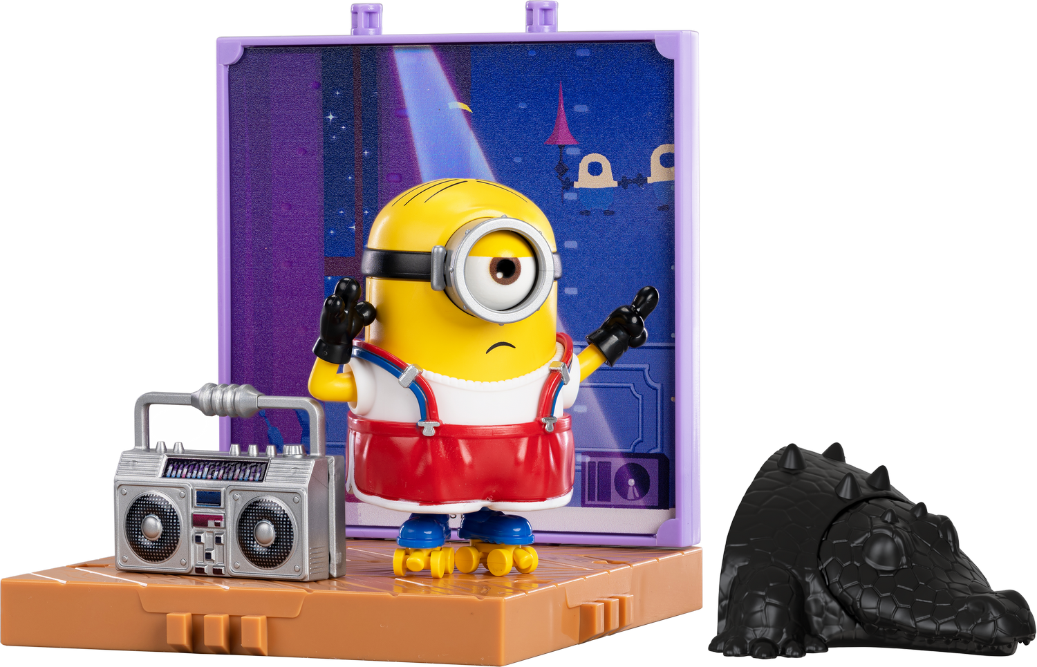 Un minion en patines está junto a un radiocasete y un juguete de caimán negro.