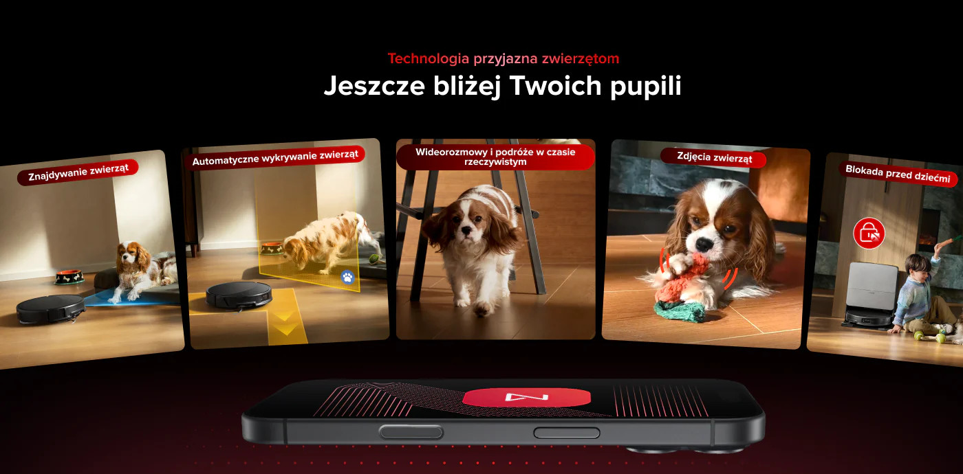 Pies leży na macie, robot sprzątający z przodu. Drugi pies gryzie zabawkę. Dziecko blisko.