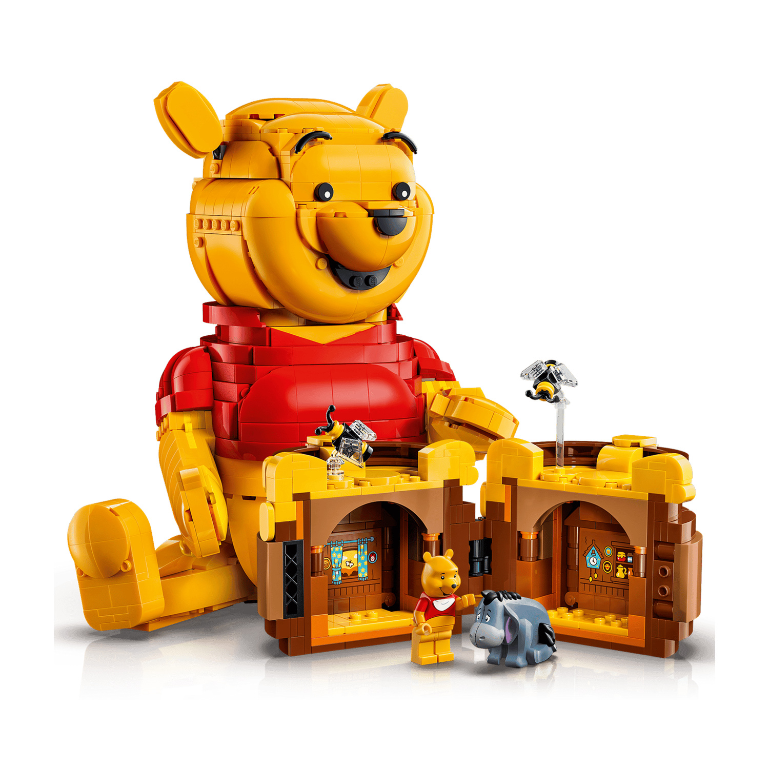 Un grande Winnie the Pooh Lego siede accanto alla sua casa con Eeyore e un'ape.