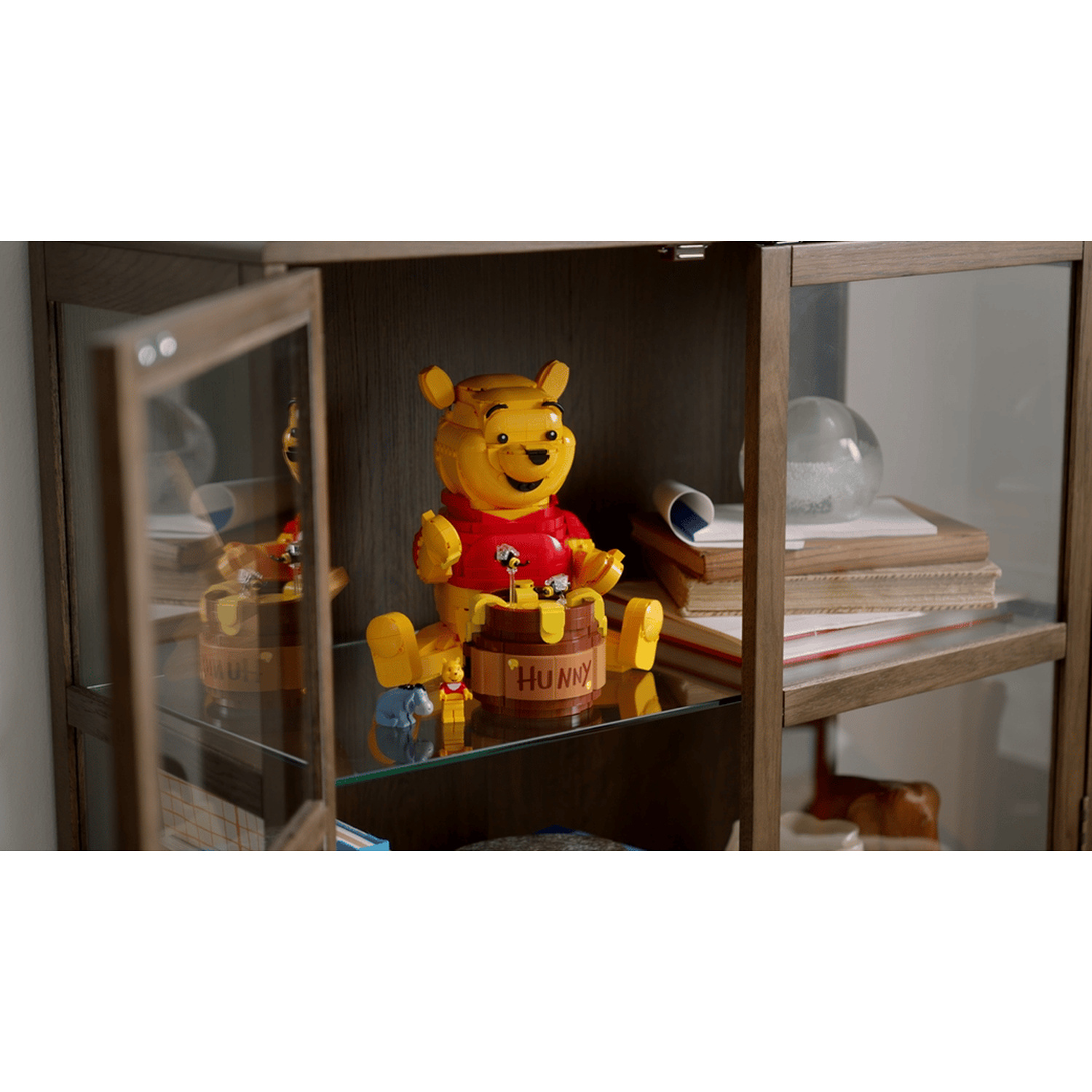 Statue di Winnie the Pooh su uno scaffale in una vetrina.