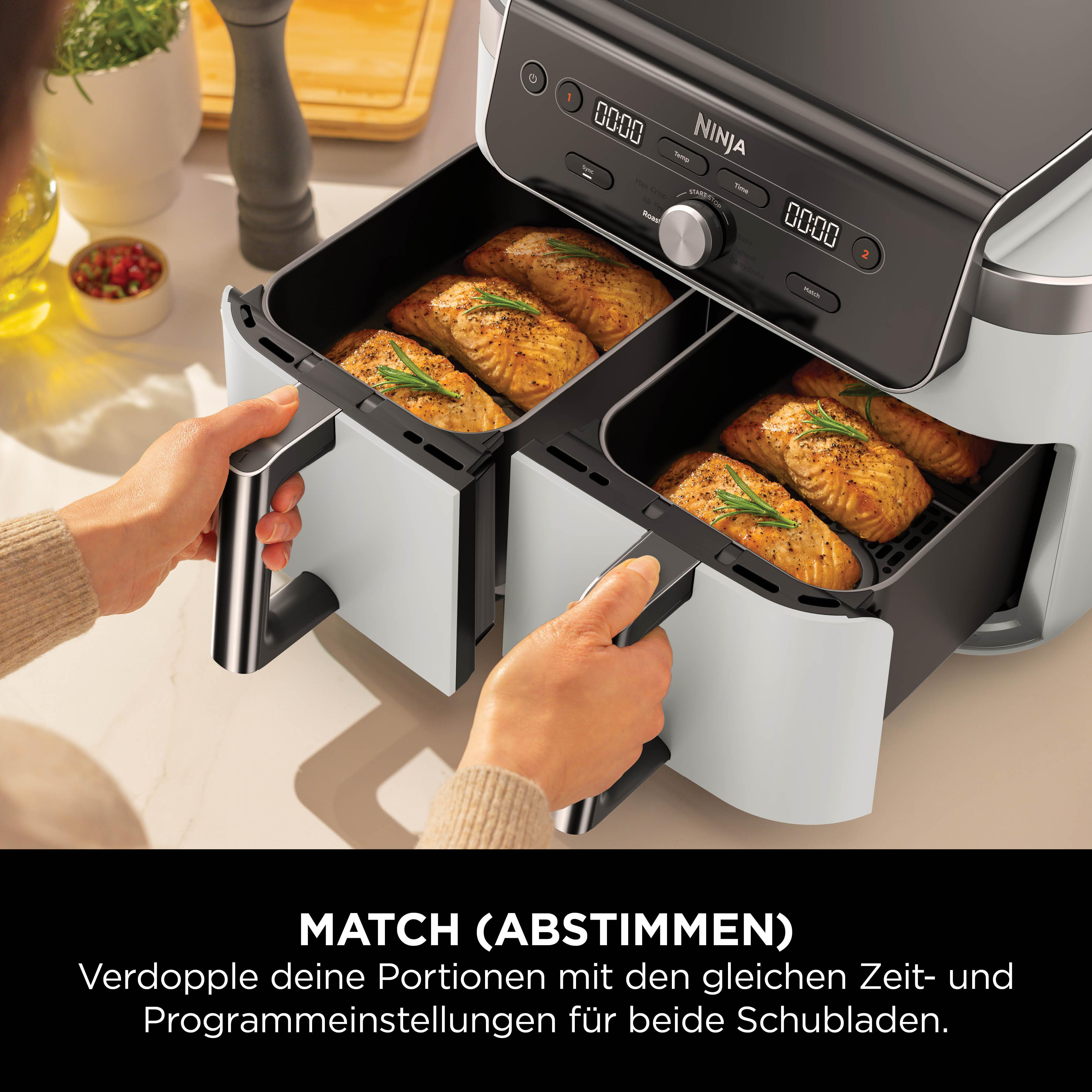Doppel-Heißluftfritteuse mit zwei Schubladen, gefüllt mit gebratenem Lachs.