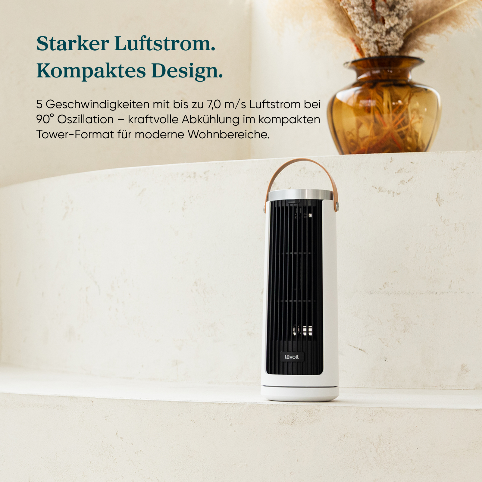 Ein weißer Turmventilator mit schwarzem Gitter und Ledergriff steht auf einem Sims.