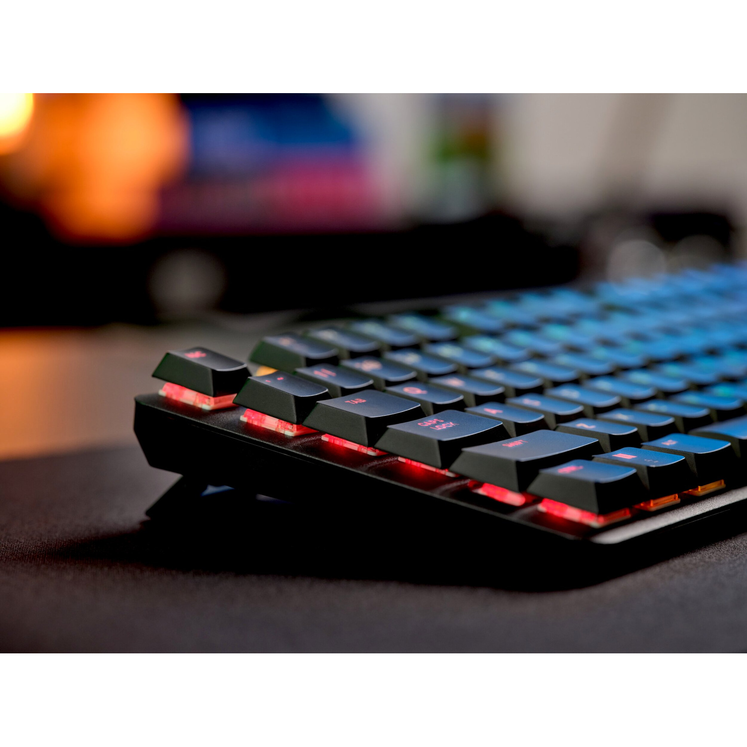 Primo piano di una tastiera nera con illuminazione rossa e blu.