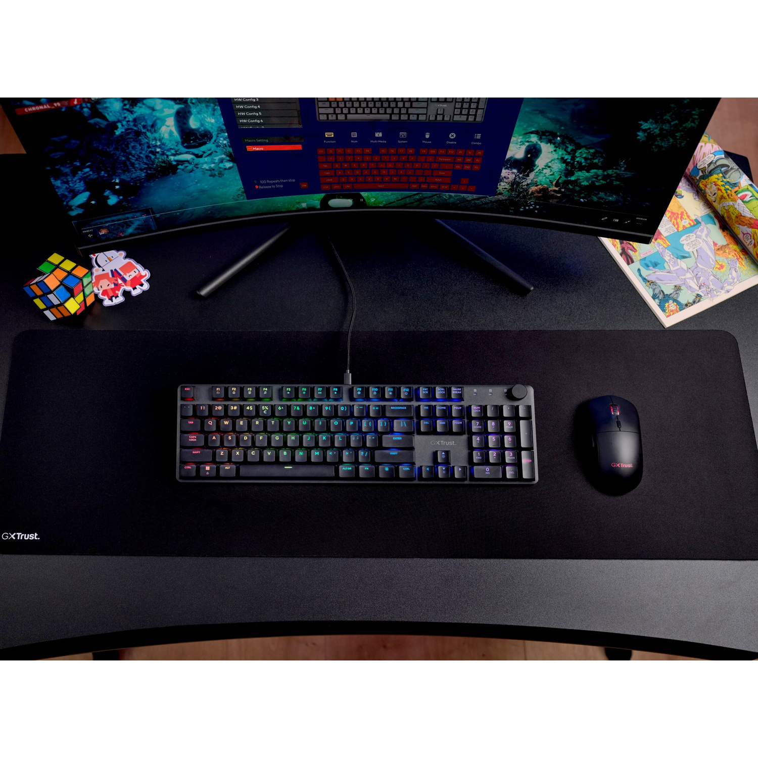 Una scrivania con tastiera, mouse, cubo di Rubik e un monitor curvo.