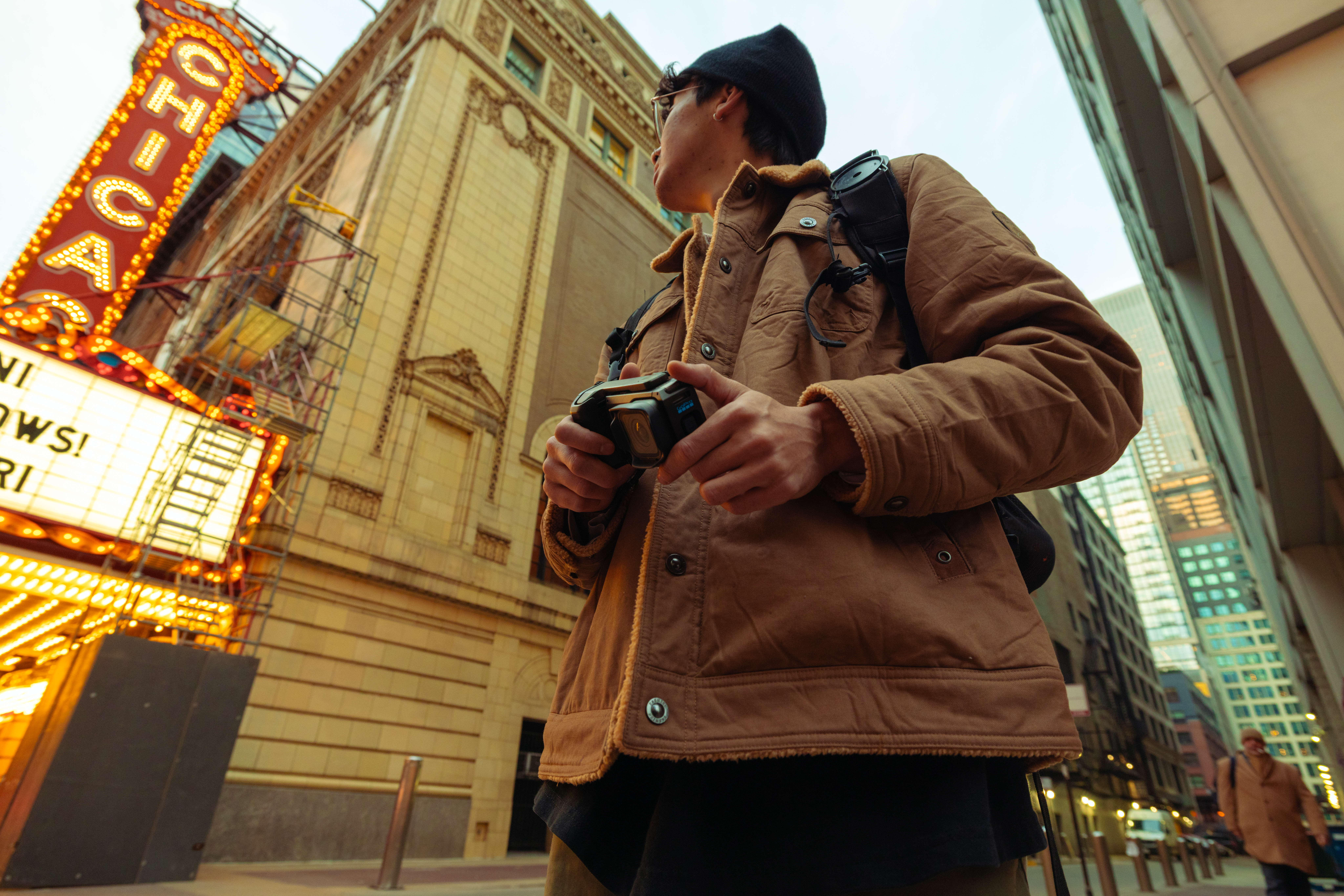 Mann mit Kamera vor dem Chicago Theatre, Gebäude im Hintergrund.