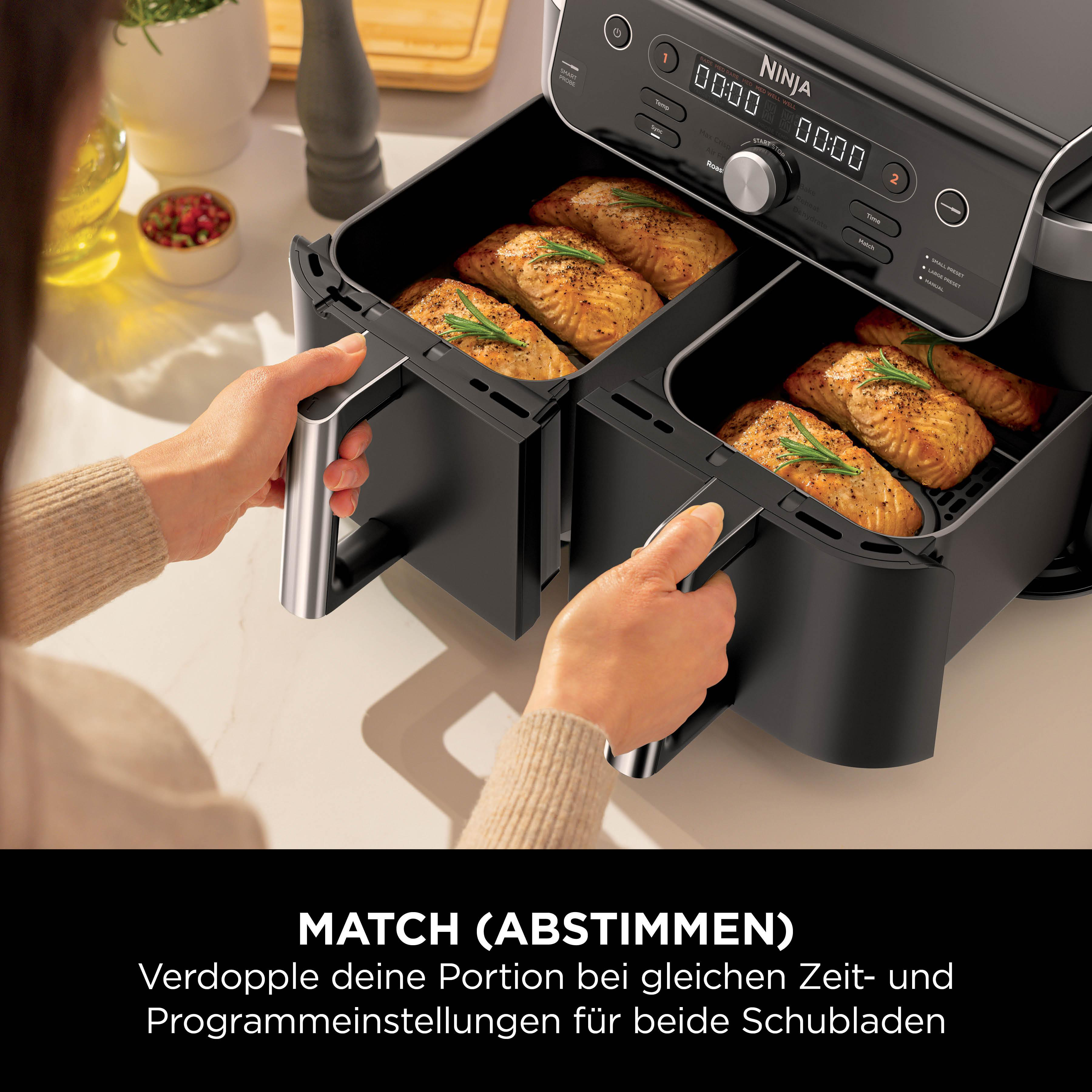 Doppelheißluftfritteuse mit zwei Schubladen, gefüllt mit gebratenem Lachs.