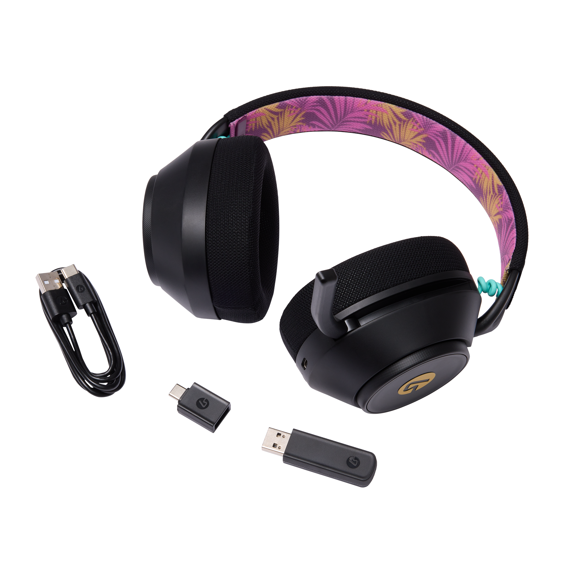 Schwarze Kopfhörer mit tropischem Stirnband, USB-Kabel und Dongles auf schwarzem Hintergrund.