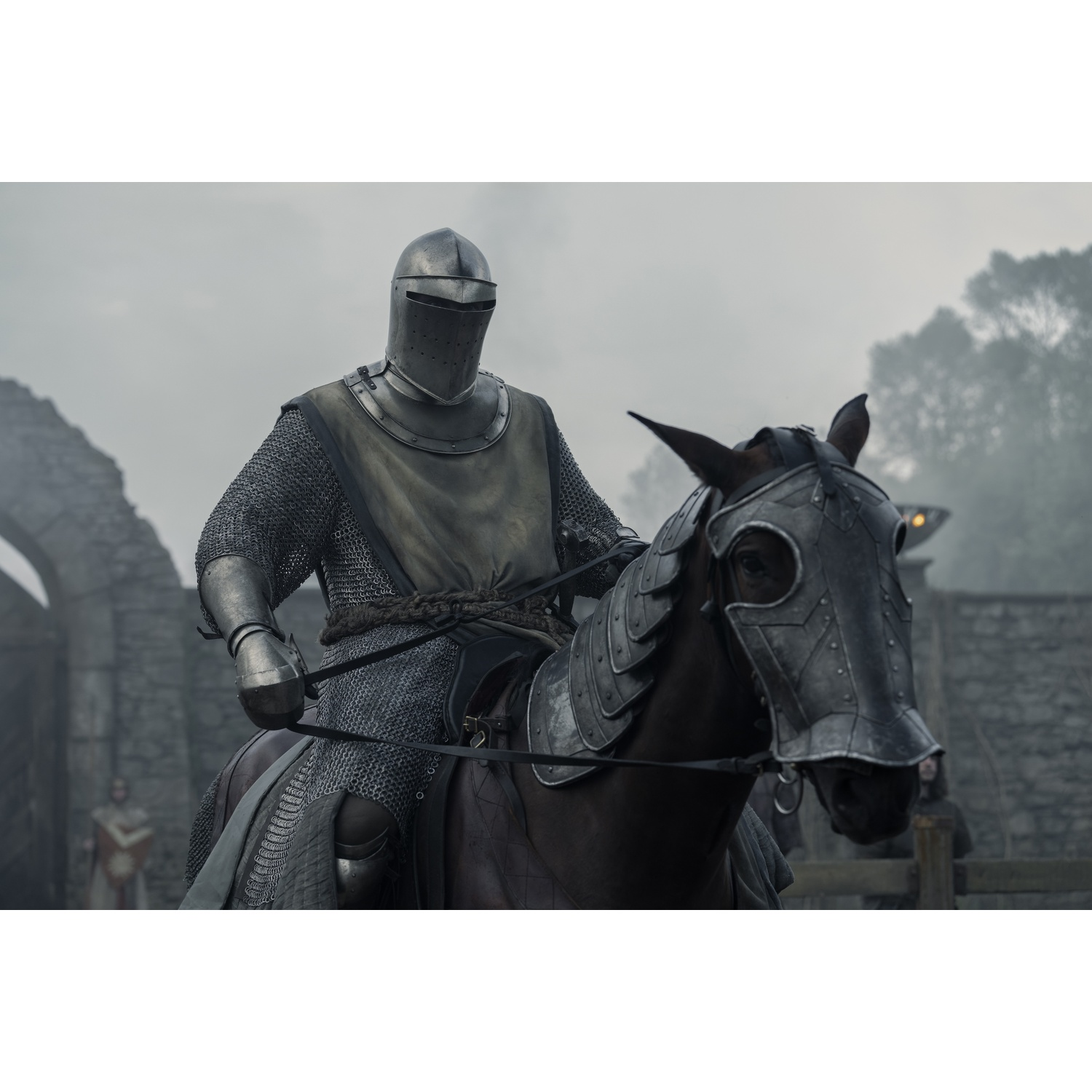 Un chevalier en armure complète monte un cheval avec armure. Un château en arrière-plan.