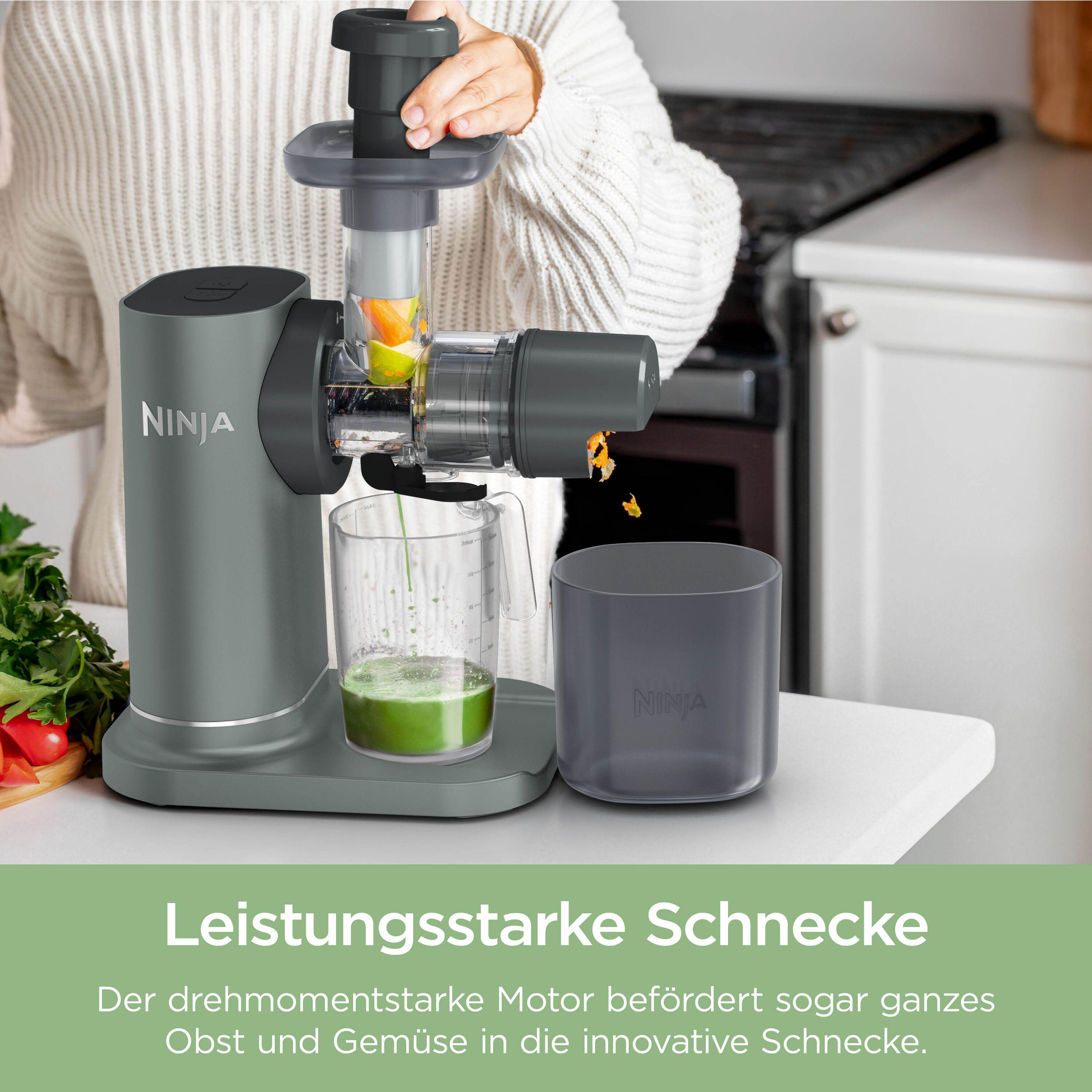 Grauer Ninja Entsafter presst grüne und orangefarbene Zutaten.