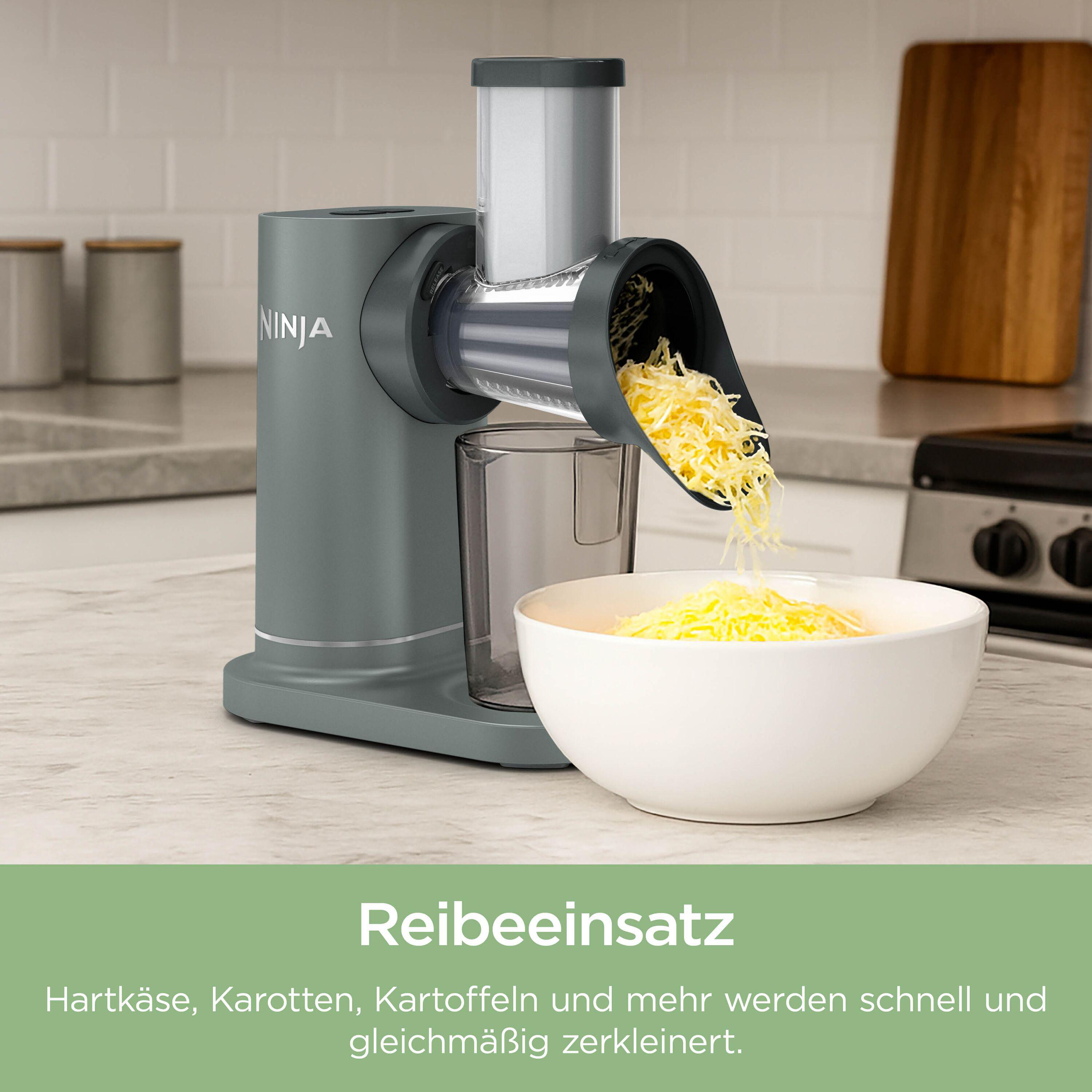 Ein grauer Ninja-Schneider zerkleinert Käse in eine weiße Schüssel.