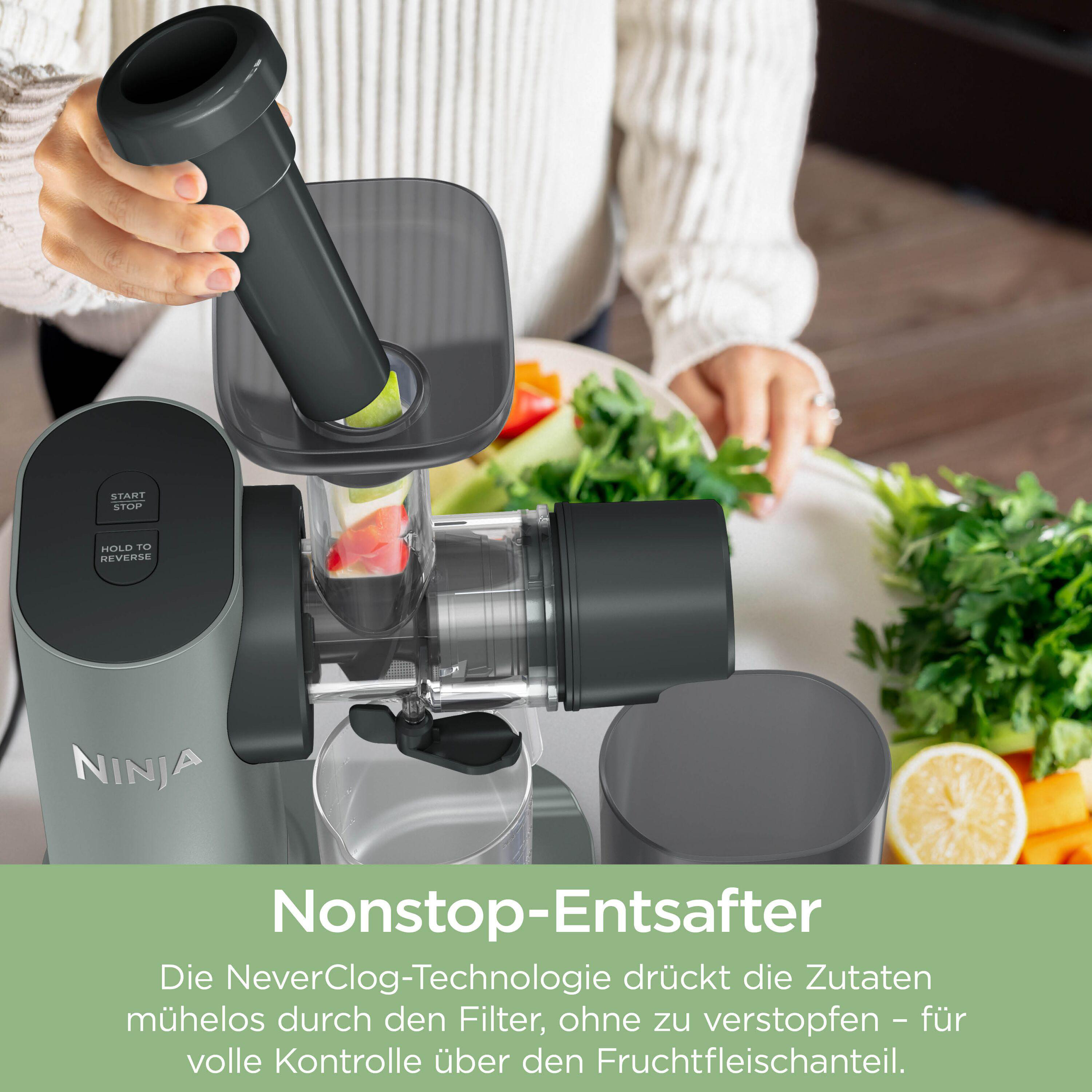 Grauer Entsafter von Ninja mit Zutaten und einem Glas Saft.