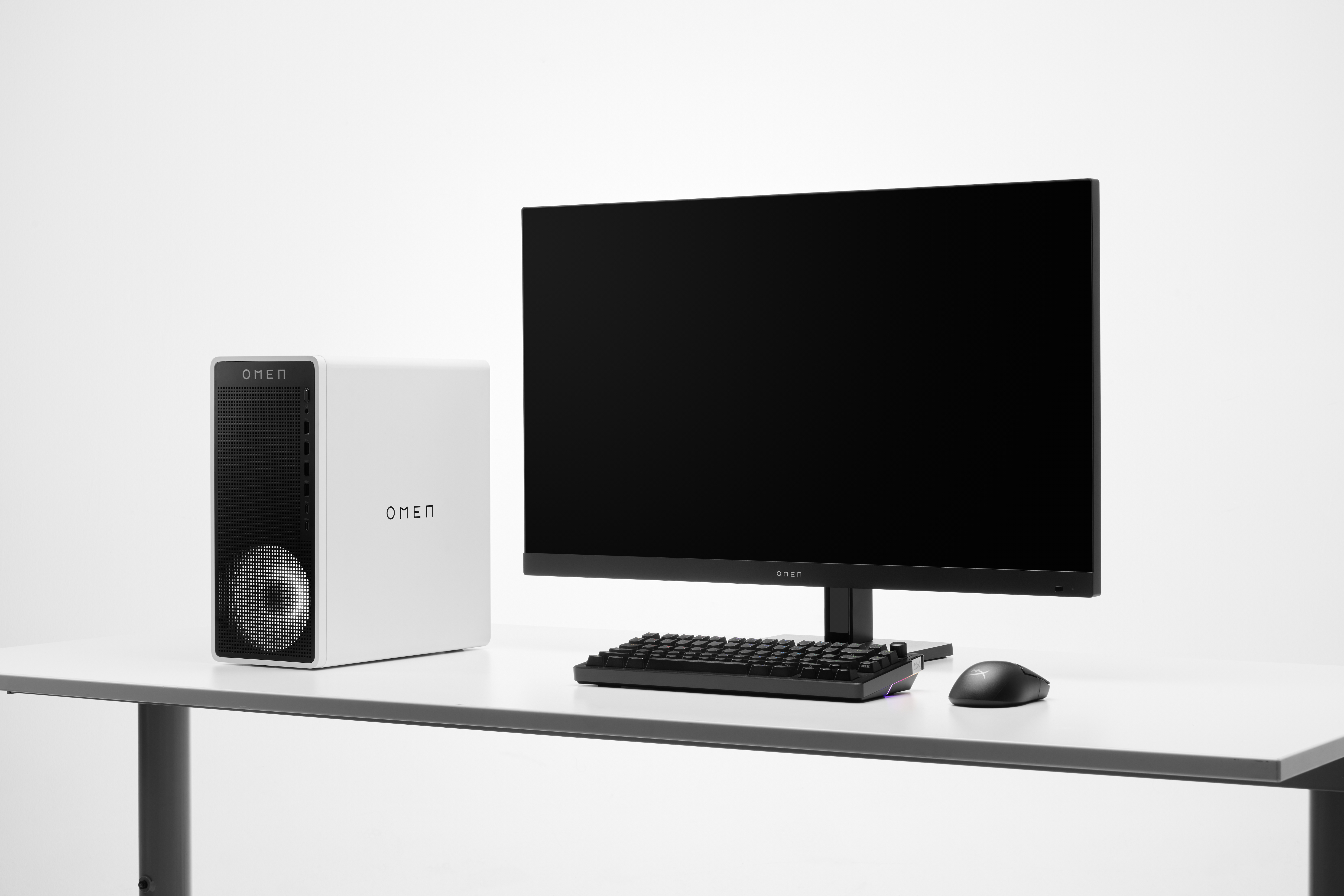 Ein weißer OMEN Gaming-PC steht neben einem schwarzen Monitor, Tastatur und Maus.