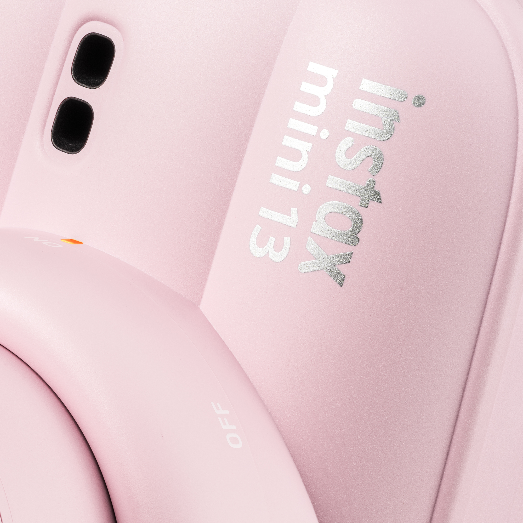 Egy rózsaszín Instax Mini 13 kamera ezüst felirattal és fekete lencsékkel.