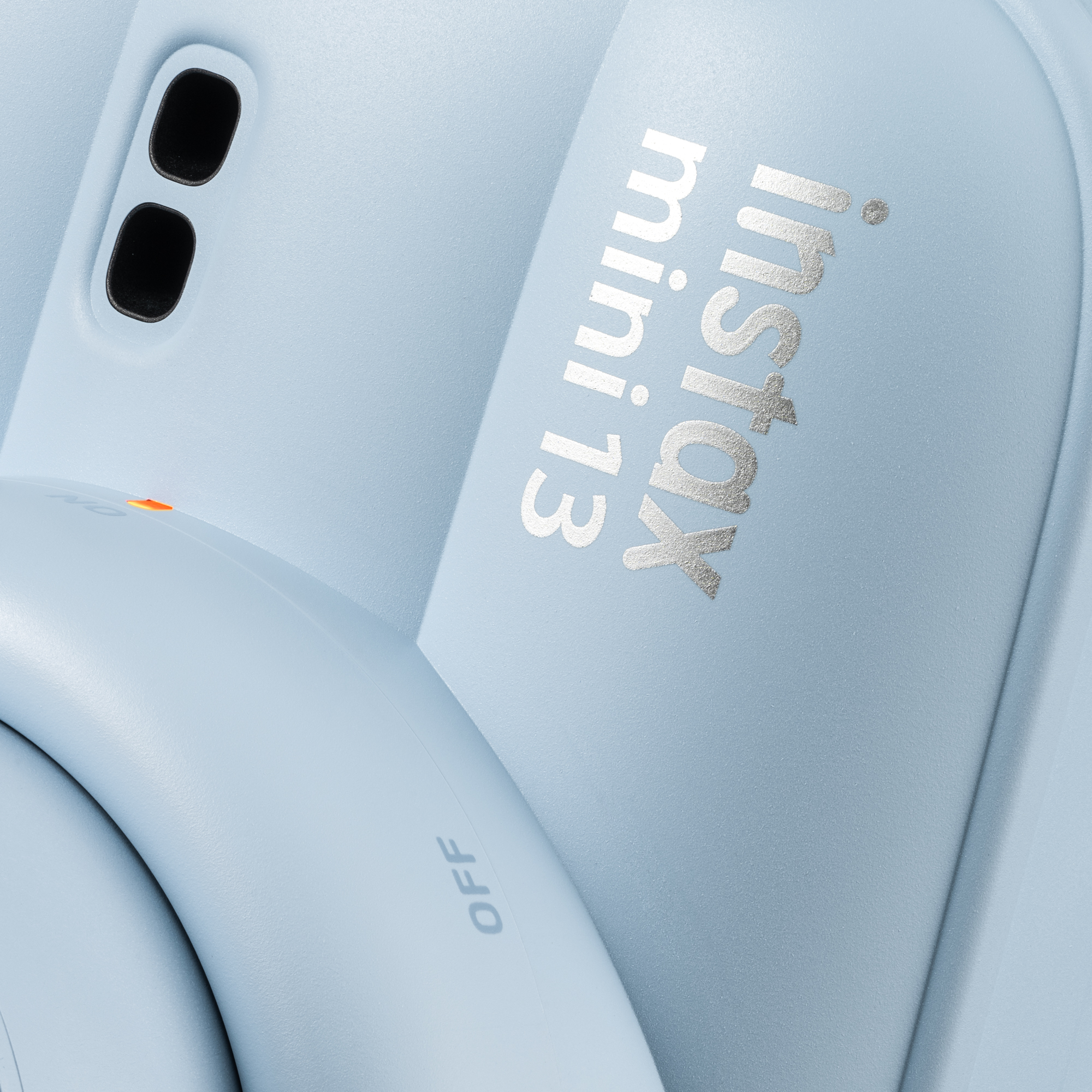 Világoskék fényképezőgép ezüst 'Instax mini 13' felirattal.