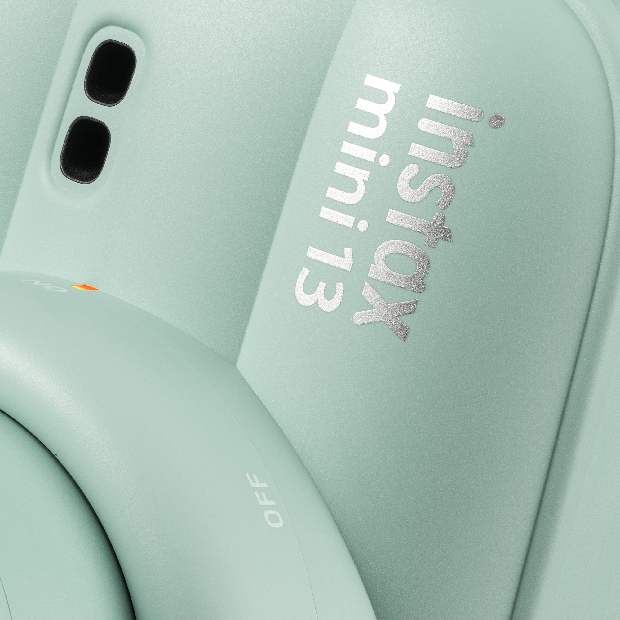 Egy mentazöld Instax Mini 13 fényképezőgép közeli képe, ezüst felirattal.