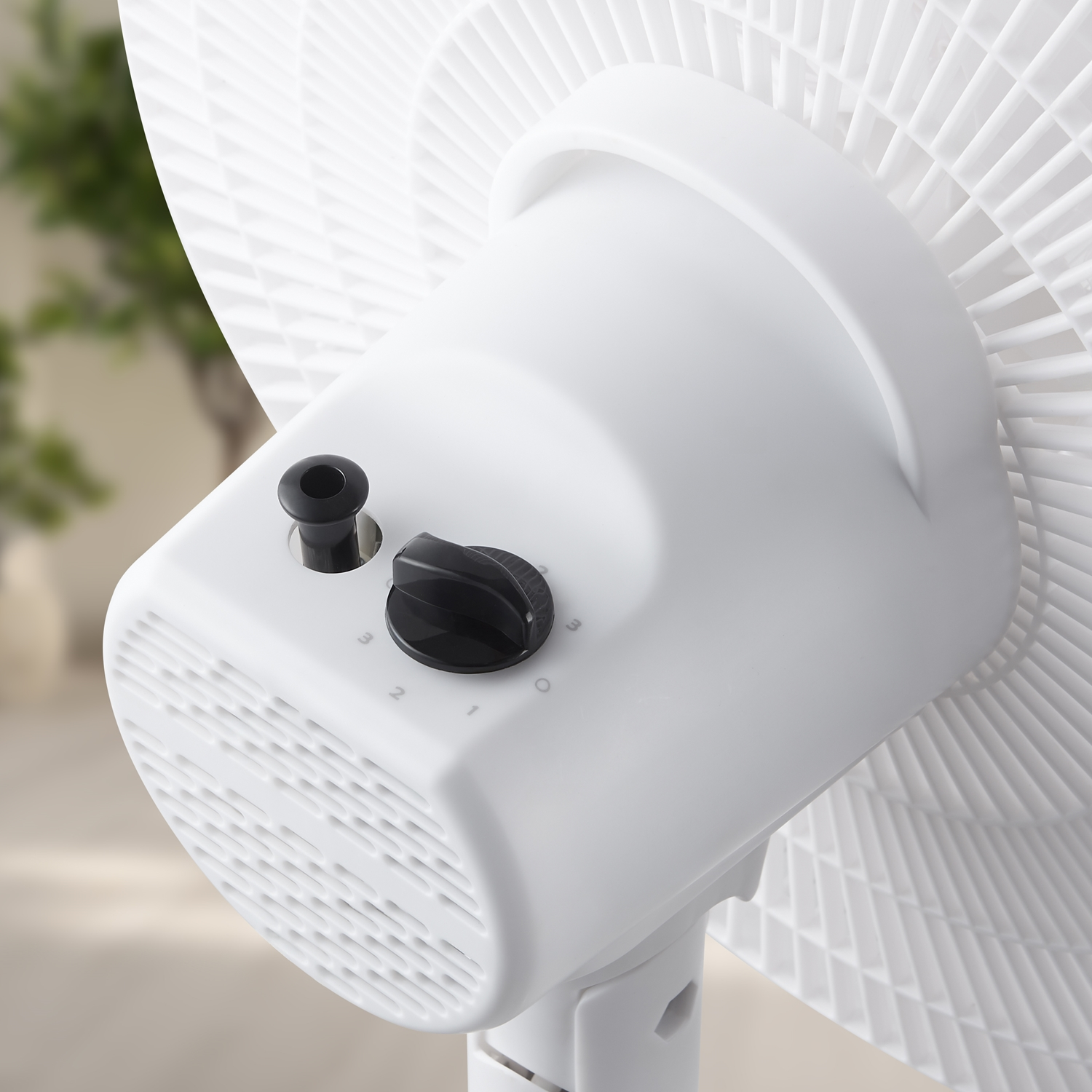 Un ventilateur blanc avec des commandes noires et des fentes de ventilation.