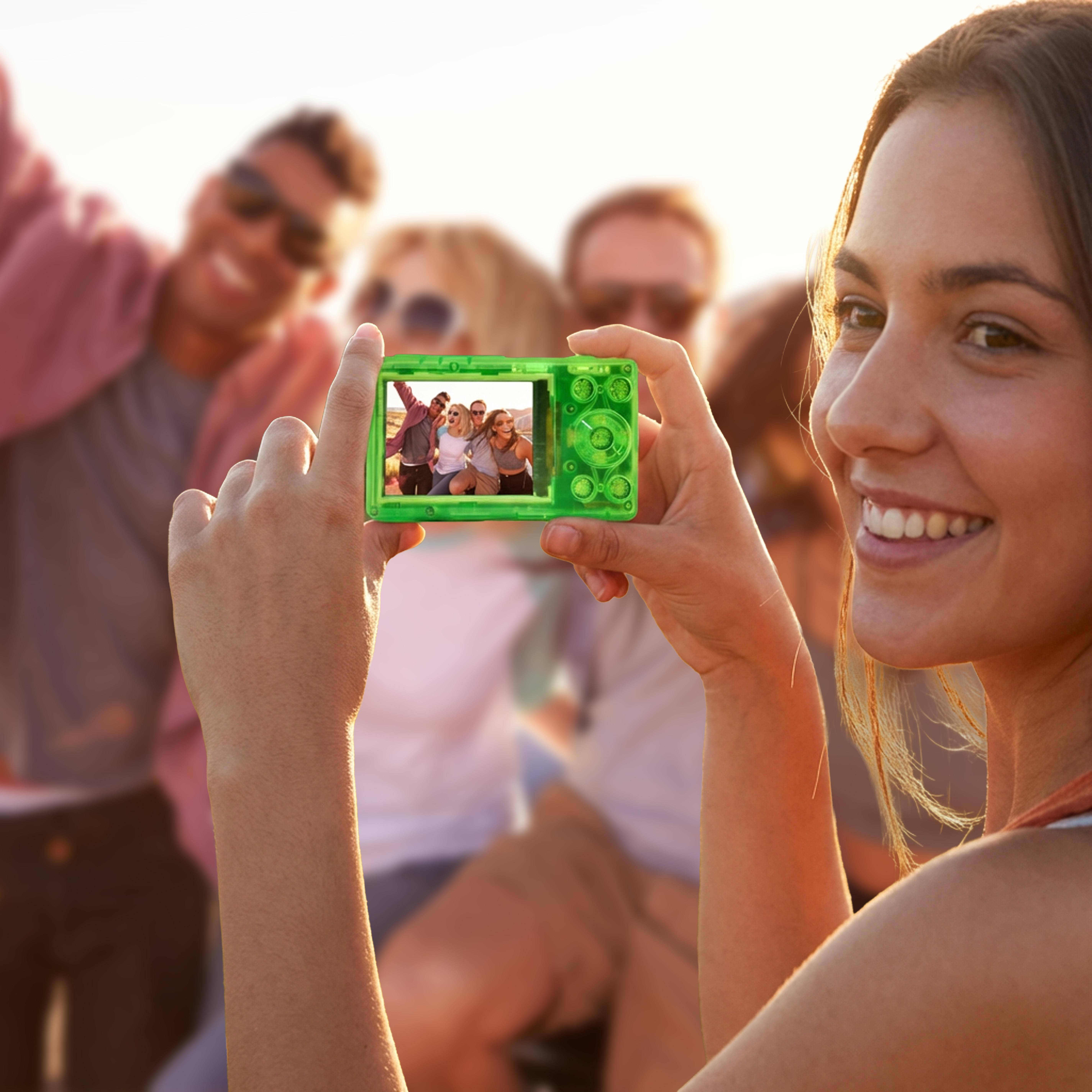 Frau hält eine grüne Digitalkamera, die eine Gruppe von Freunden zeigt.
