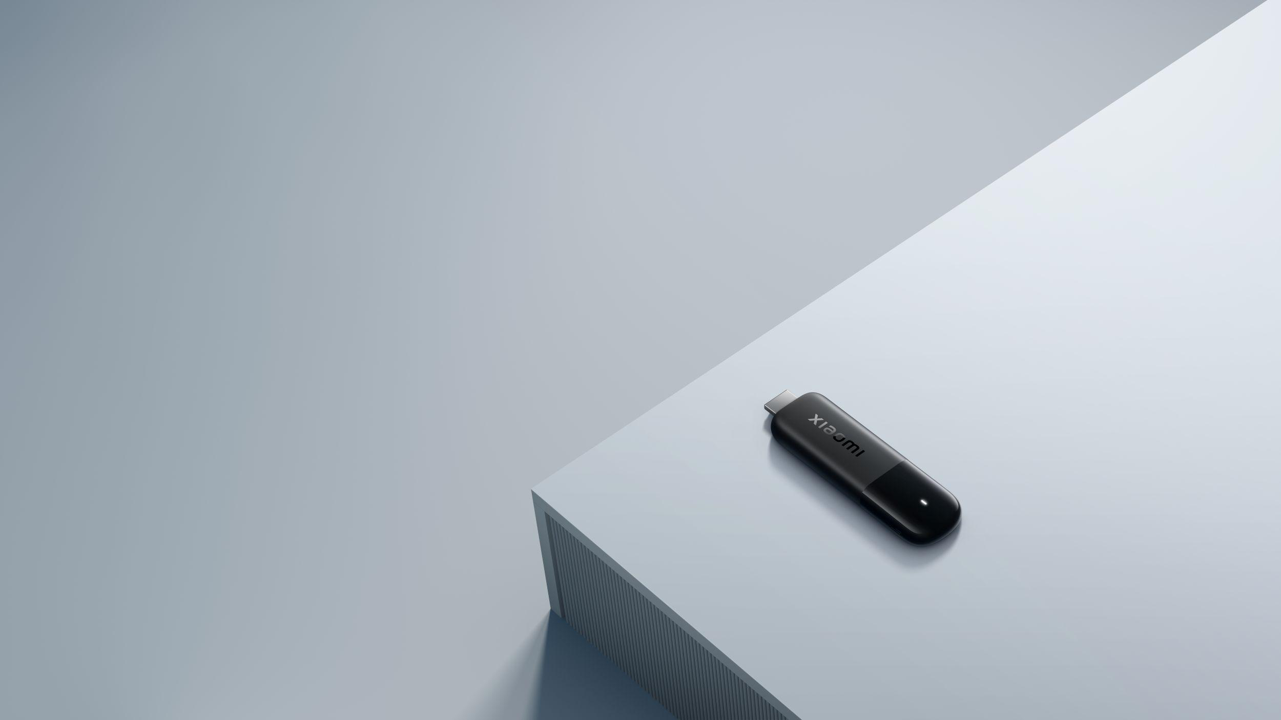 Ein schwarzer USB-Stick mit dem Xiaomi-Logo liegt auf einer grauen Oberfläche.