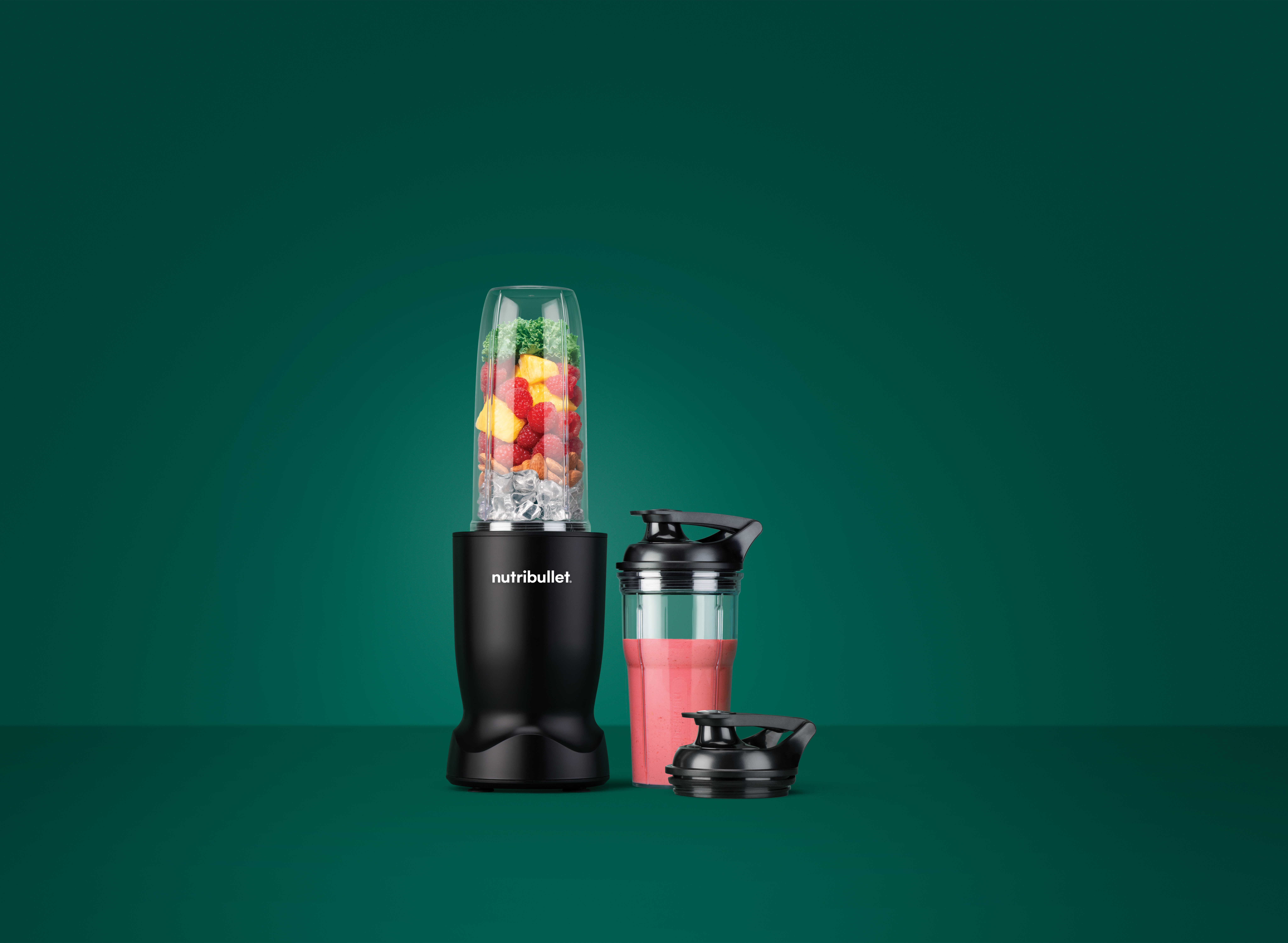 Fekete turmixgép gyümölcsös pohárral, jéggel, smoothie-s pohárral és fedéllel.