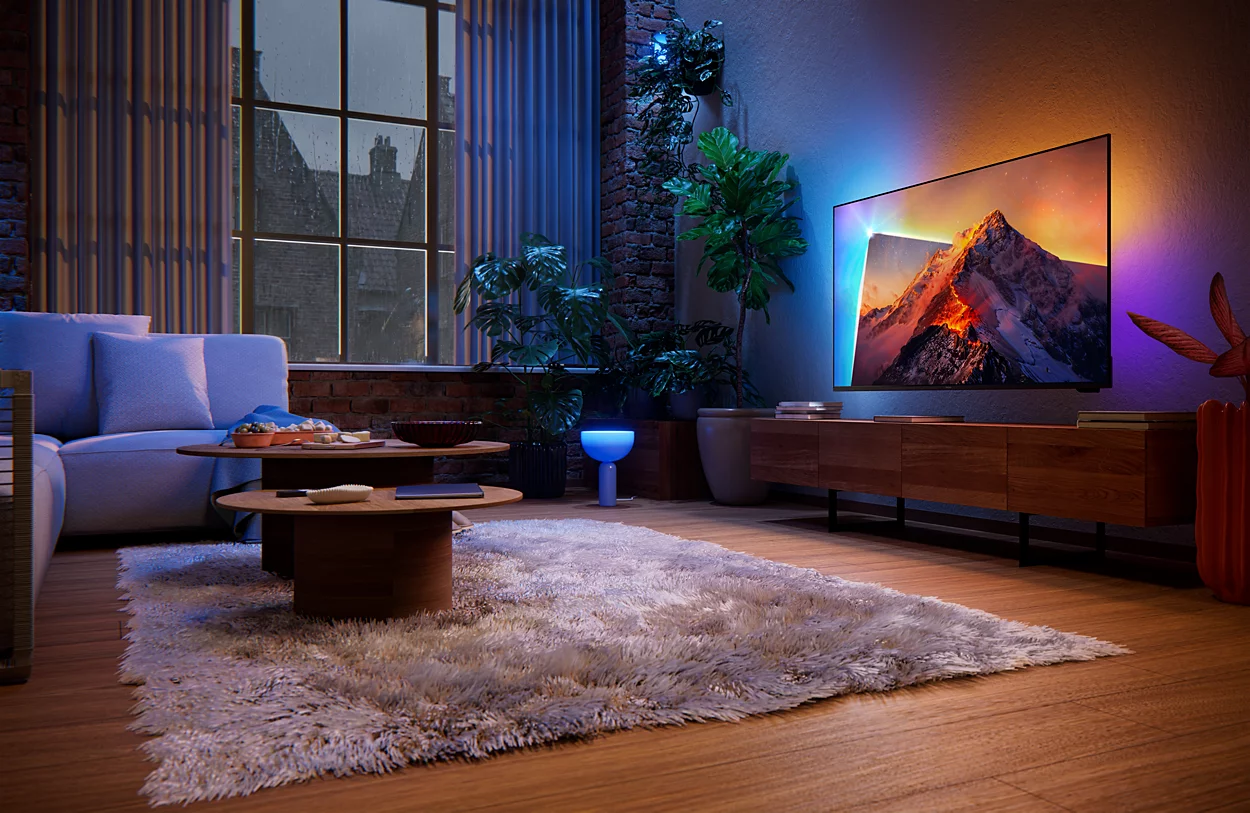 Ein Wohnzimmer mit Sofa, Couchtisch, Teppich und Fernseher bei Nacht.