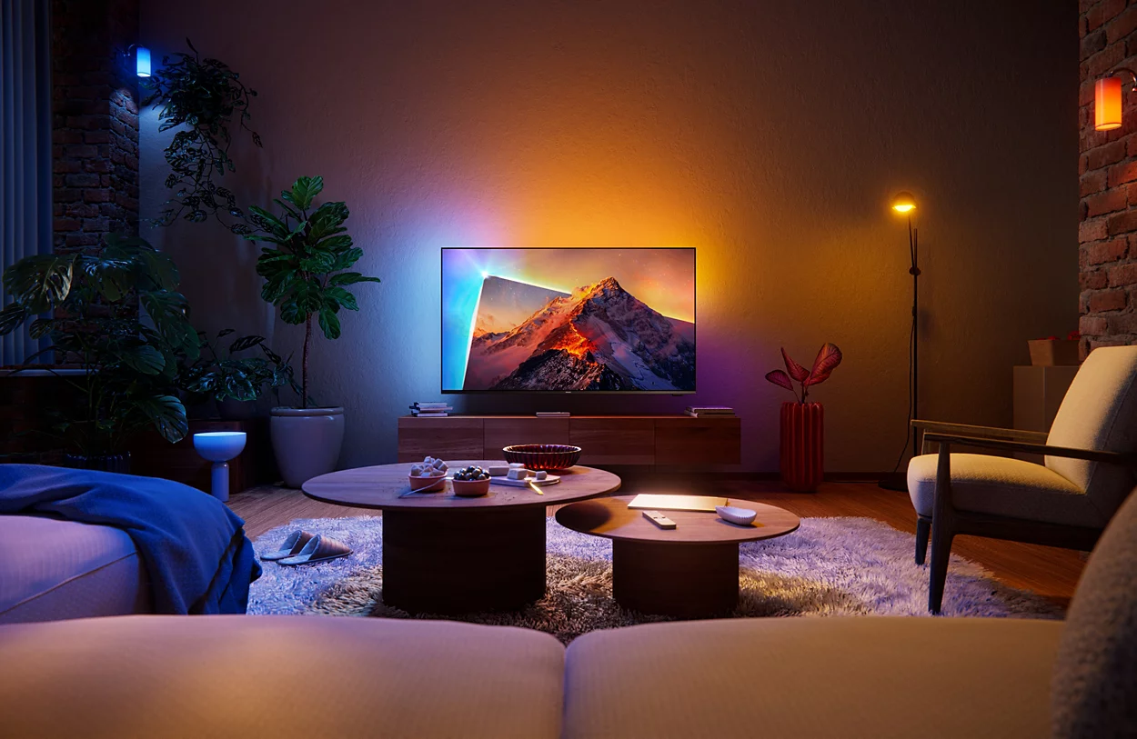 Ein Wohnzimmer mit einem großen Fernseher, der eine Berglandschaft zeigt.