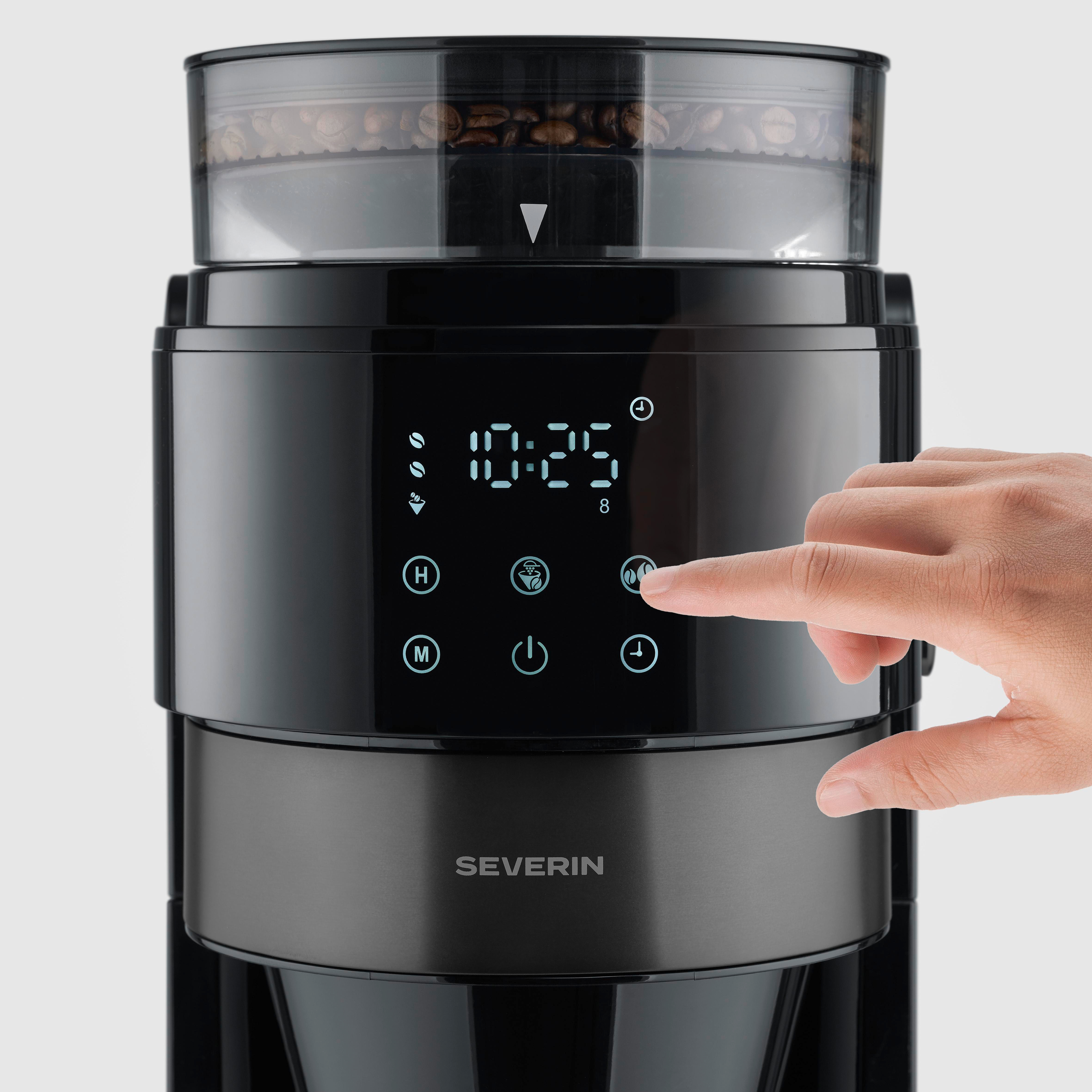 Eine Hand drückt auf die Bedienelemente einer schwarzen Kaffeemaschine mit digitaler Anzeige.