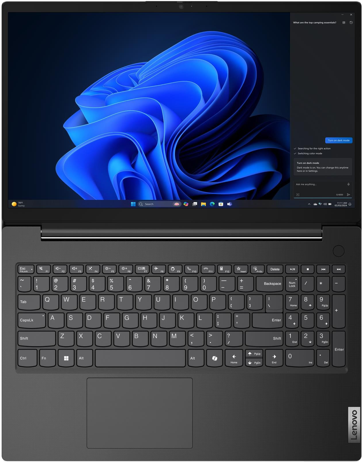 Egy nyitott laptop Windows 11-et jelenít meg kék hullámos háttérrel.