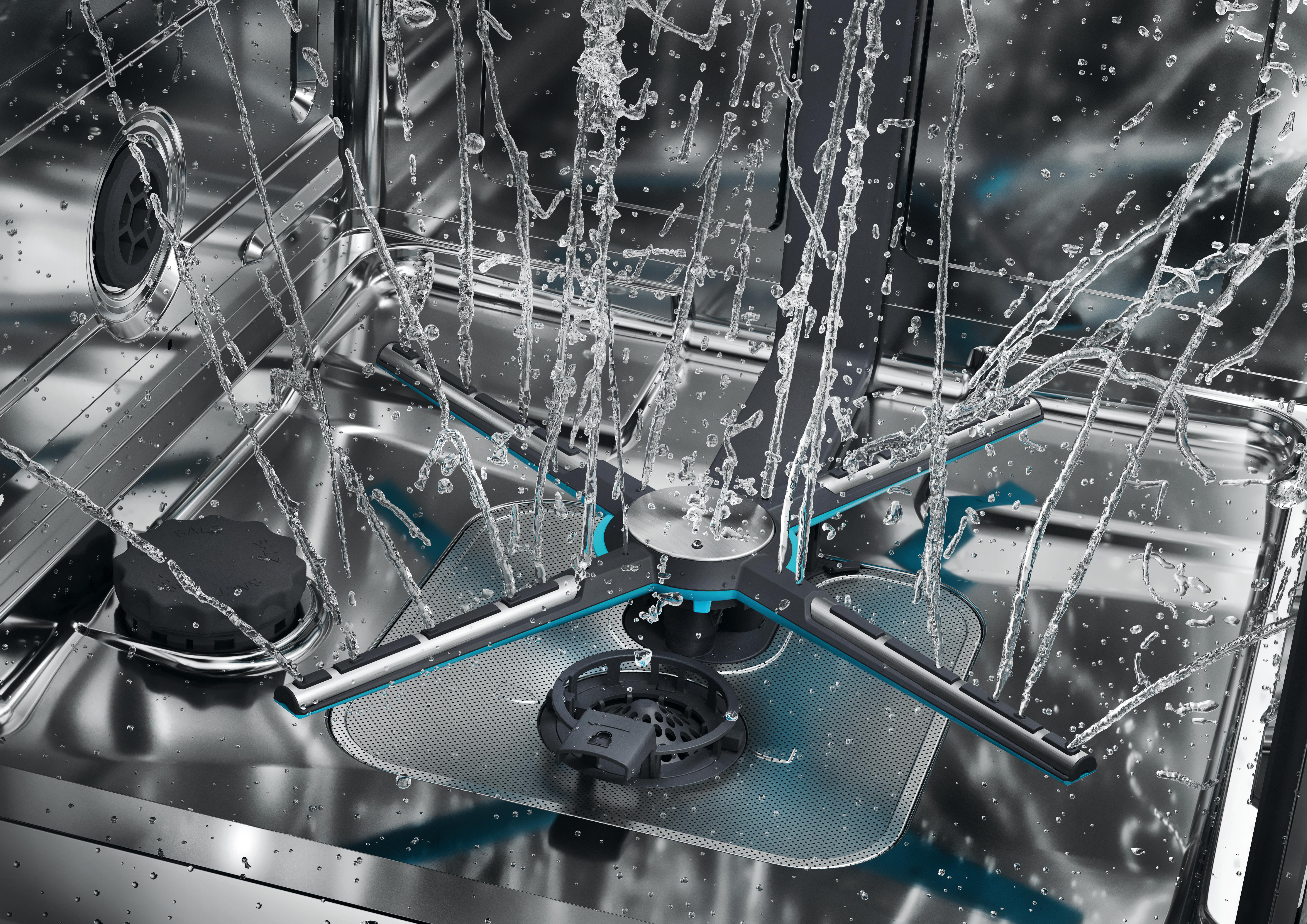 Wasserstrahlen spritzen auf den Boden eines Geschirrspülers mit Metalloberflächen.