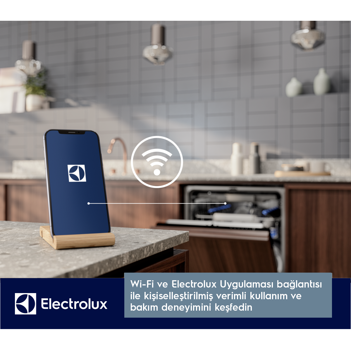 Electrolux logosu olan akıllı telefon, açık bir bulaşık makinesinin yanında mutfak tezgahında duruyor.
