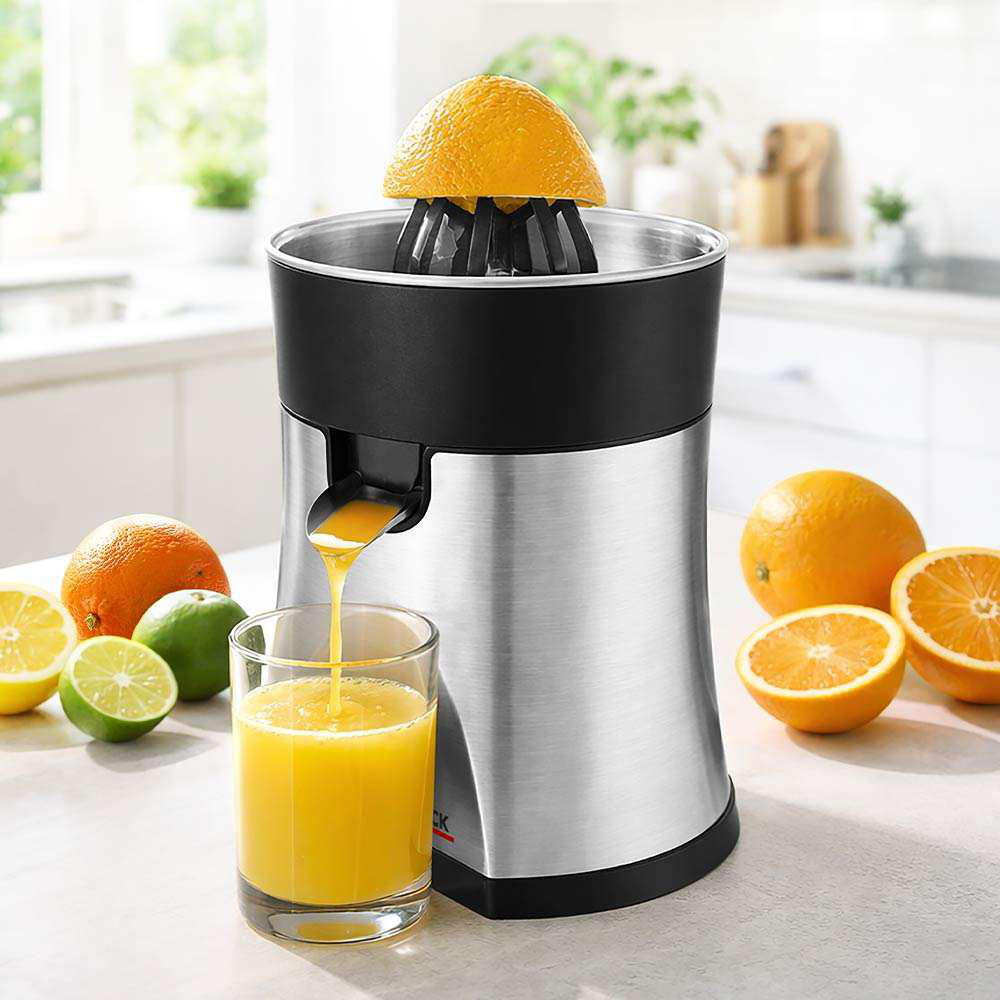 Ein elektrischer Zitrusentsafter presst Orangen aus, während Saft in ein Glas fließt.