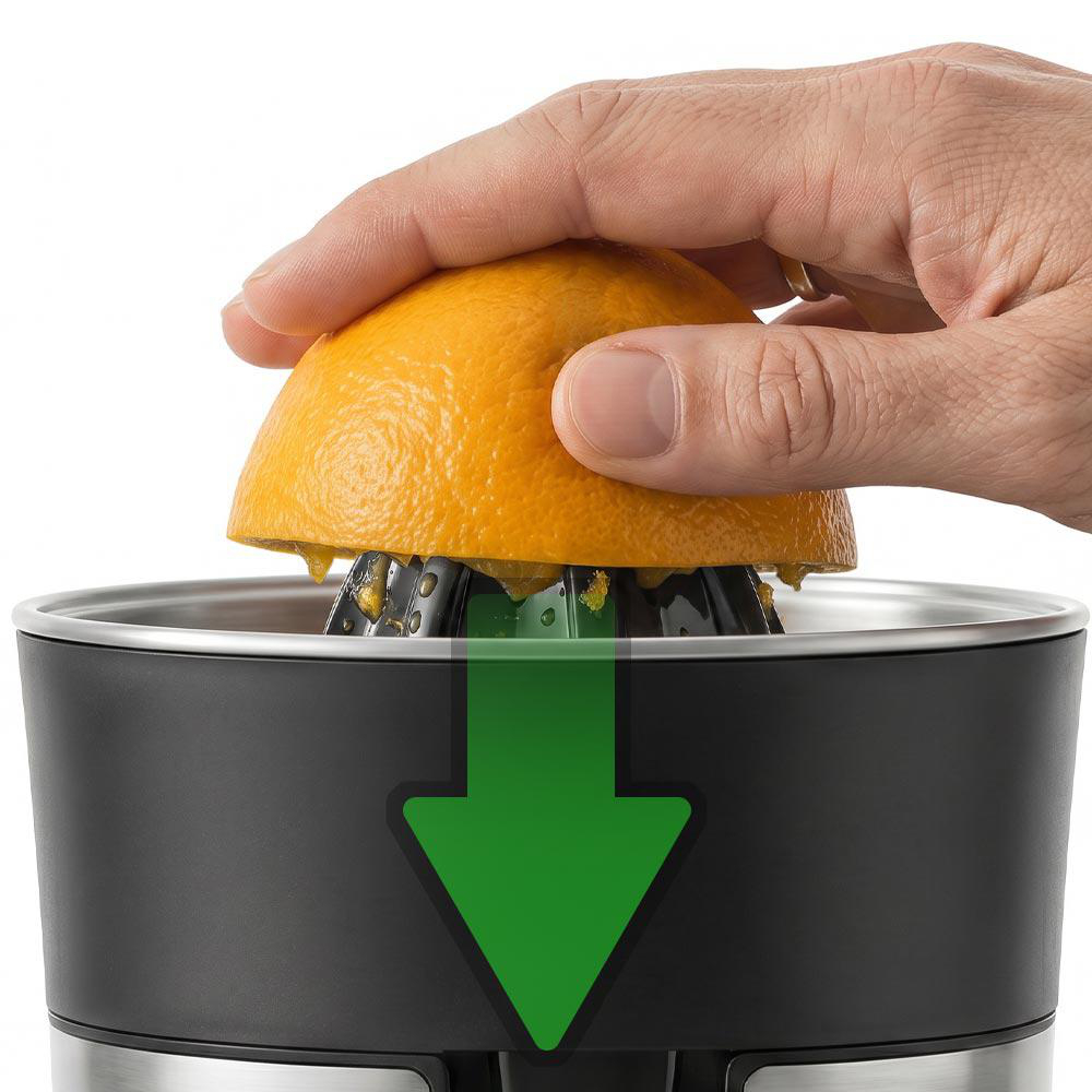 Eine Hand drückt eine halbe Orange auf einen Entsafter. Saft tropft herunter.