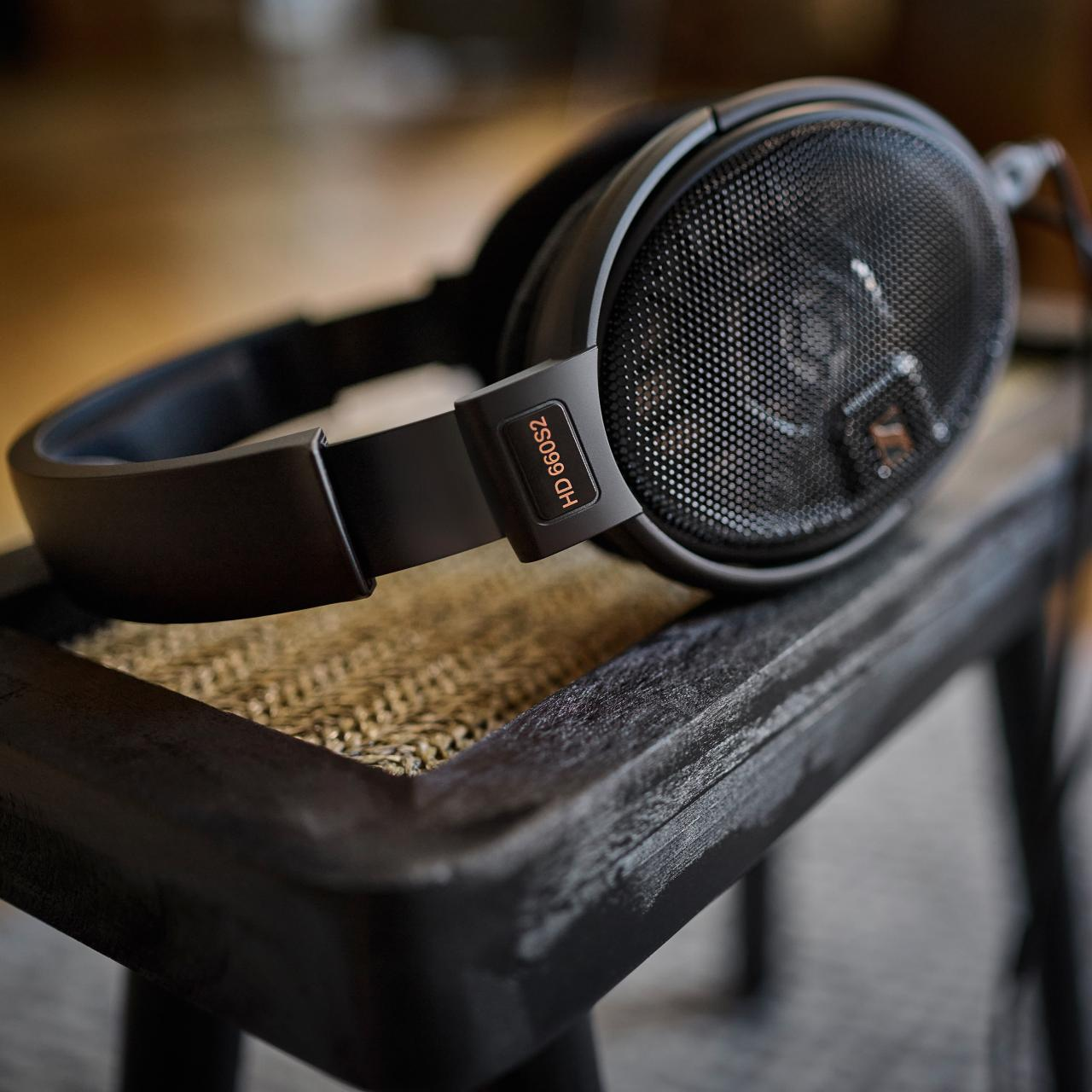 Koyu ahşap sandalye üzerinde HD 660S2 yazılı siyah kulaklık.