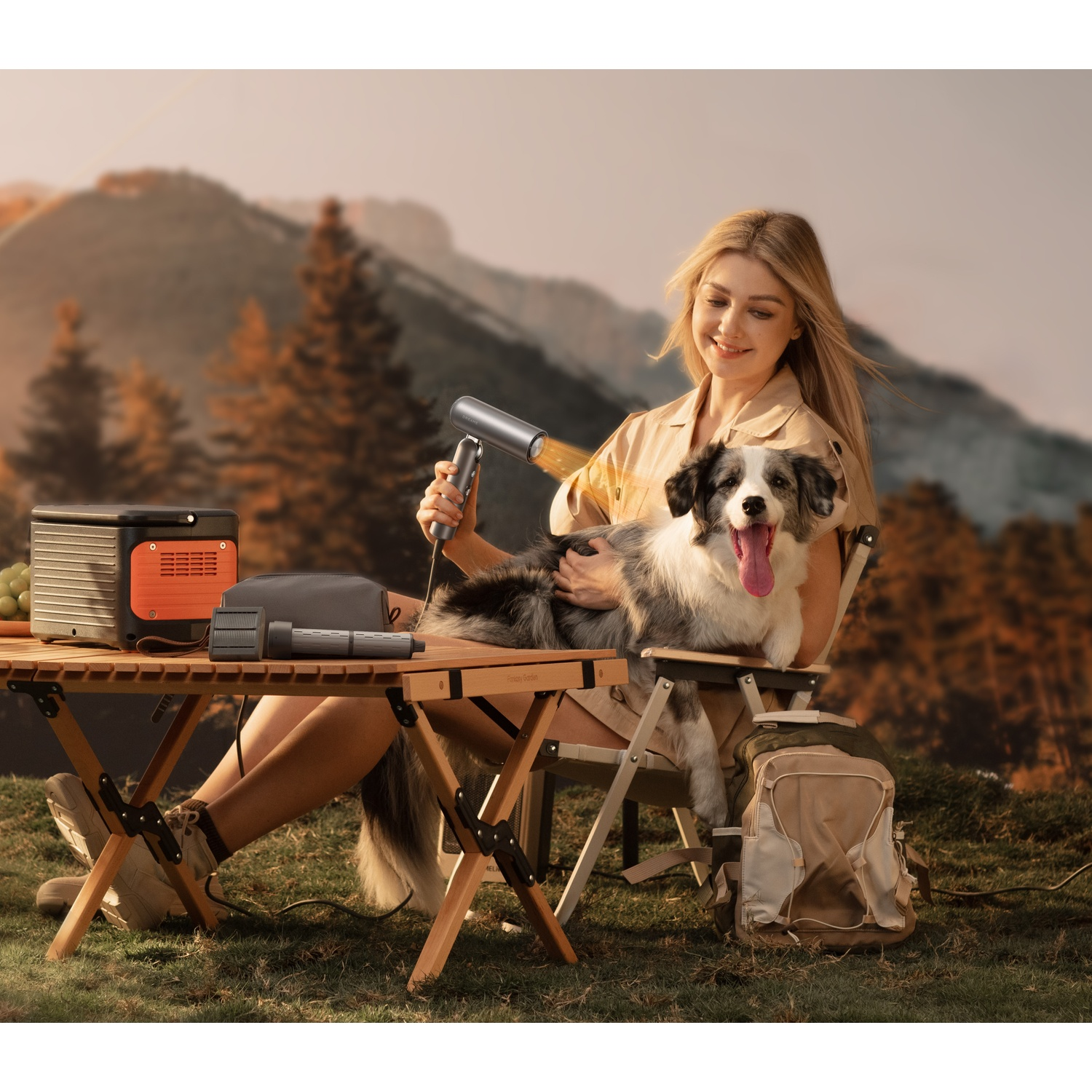 Vrouw met hond buiten, droogt de vacht van de hond met een haardroger.