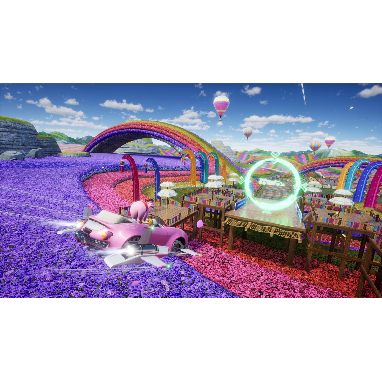Een roze auto met Amy Rose rijdt door een kleurrijk bloemenveld met regenboog en heteluchtballonnen.