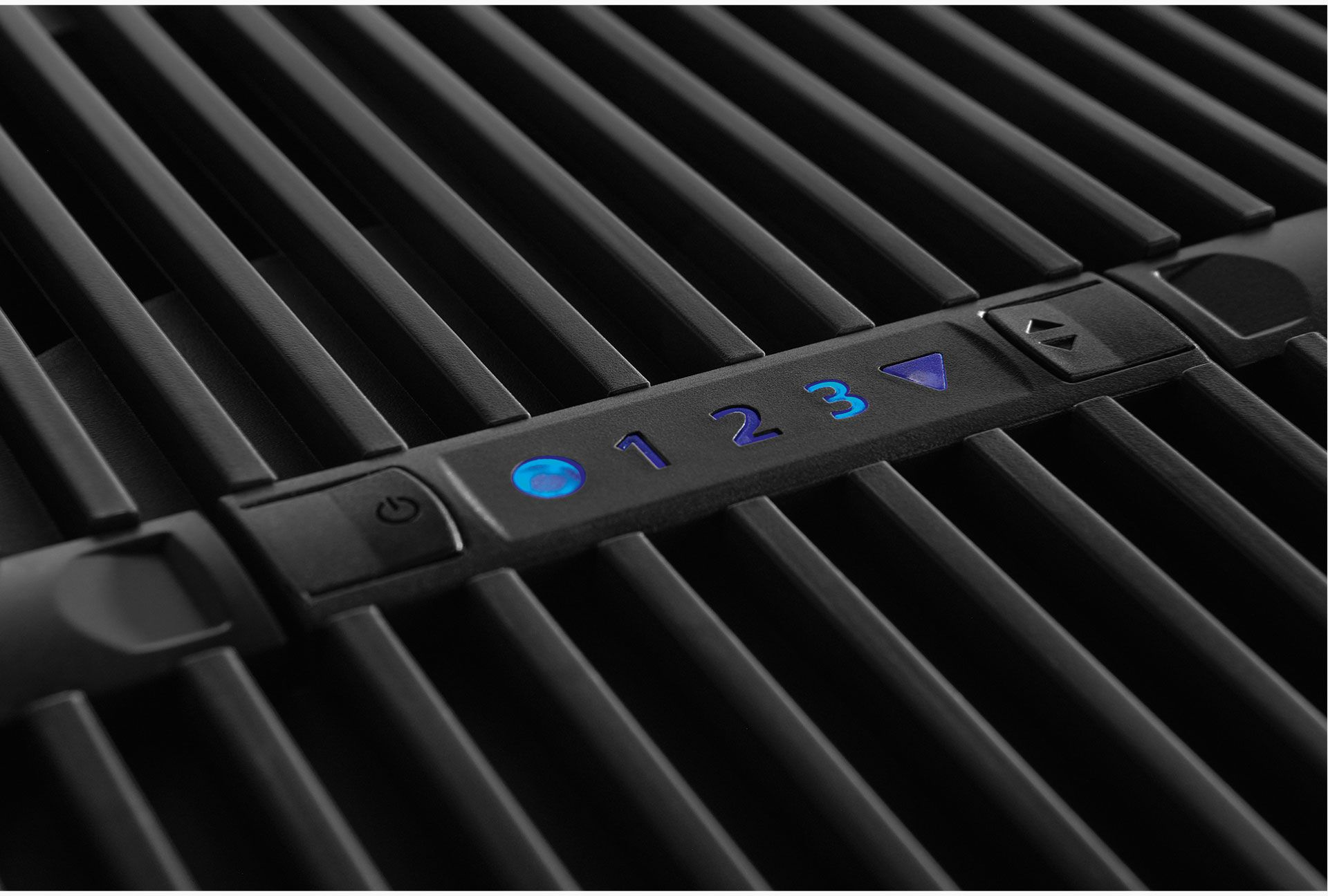 Nahaufnahme eines schwarzen Grills mit leuchtenden blauen Zahlen 1, 2, 3 und einem Power-Symbol.