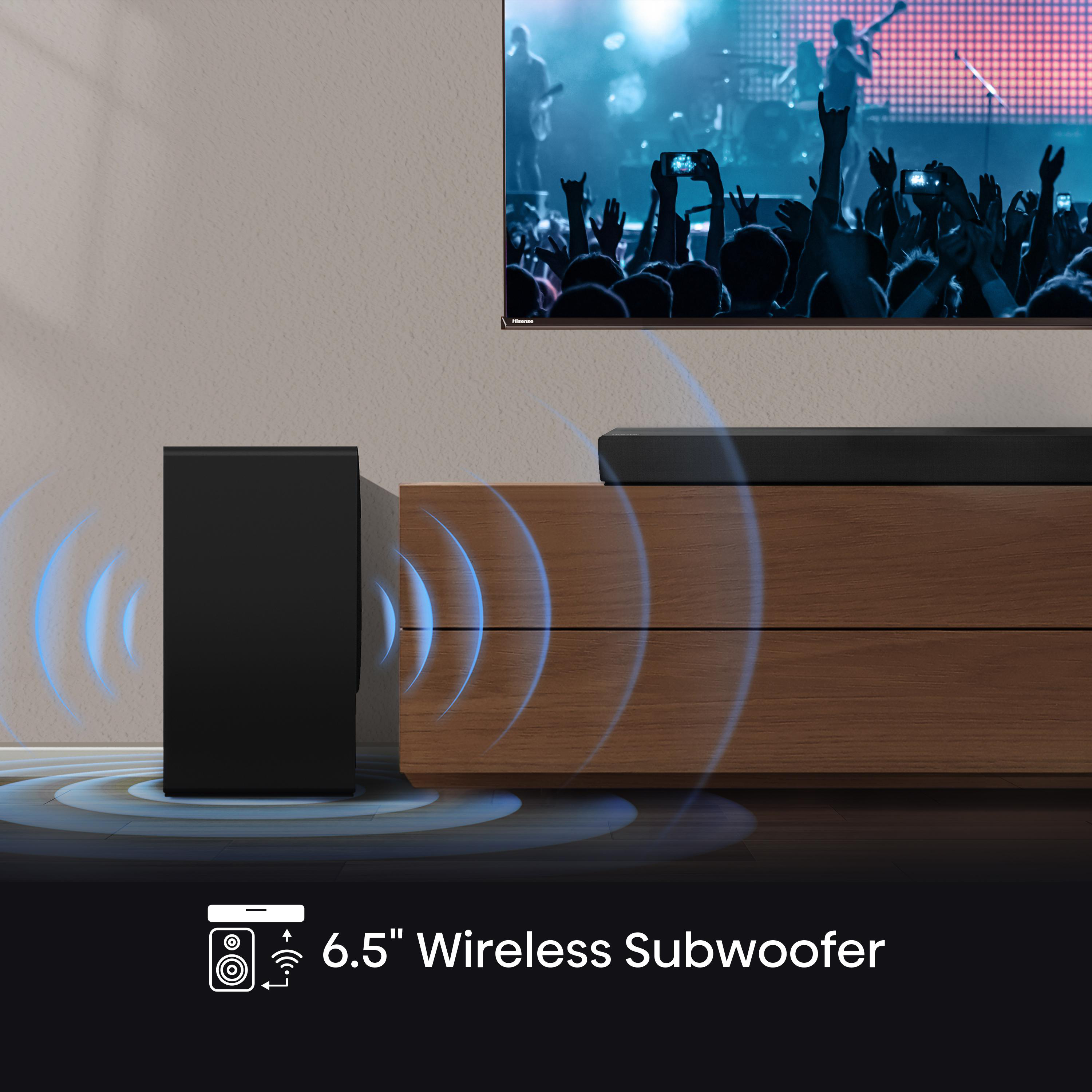 Schwarzer Subwoofer mit blauen Schallwellen neben einem Holzschrank und einem Fernseher.