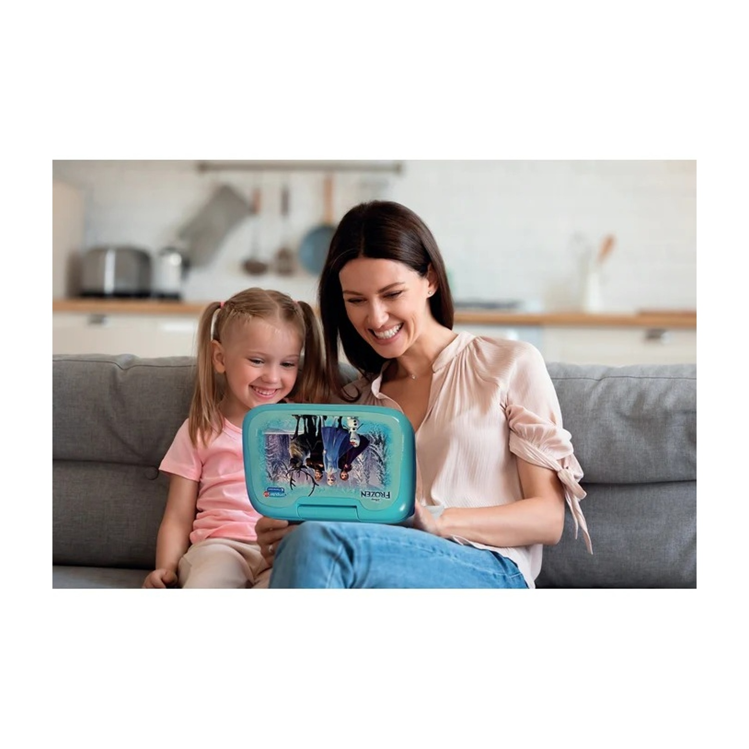 Donna e bambina su divano tengono un portamerenda blu con personaggi Frozen.