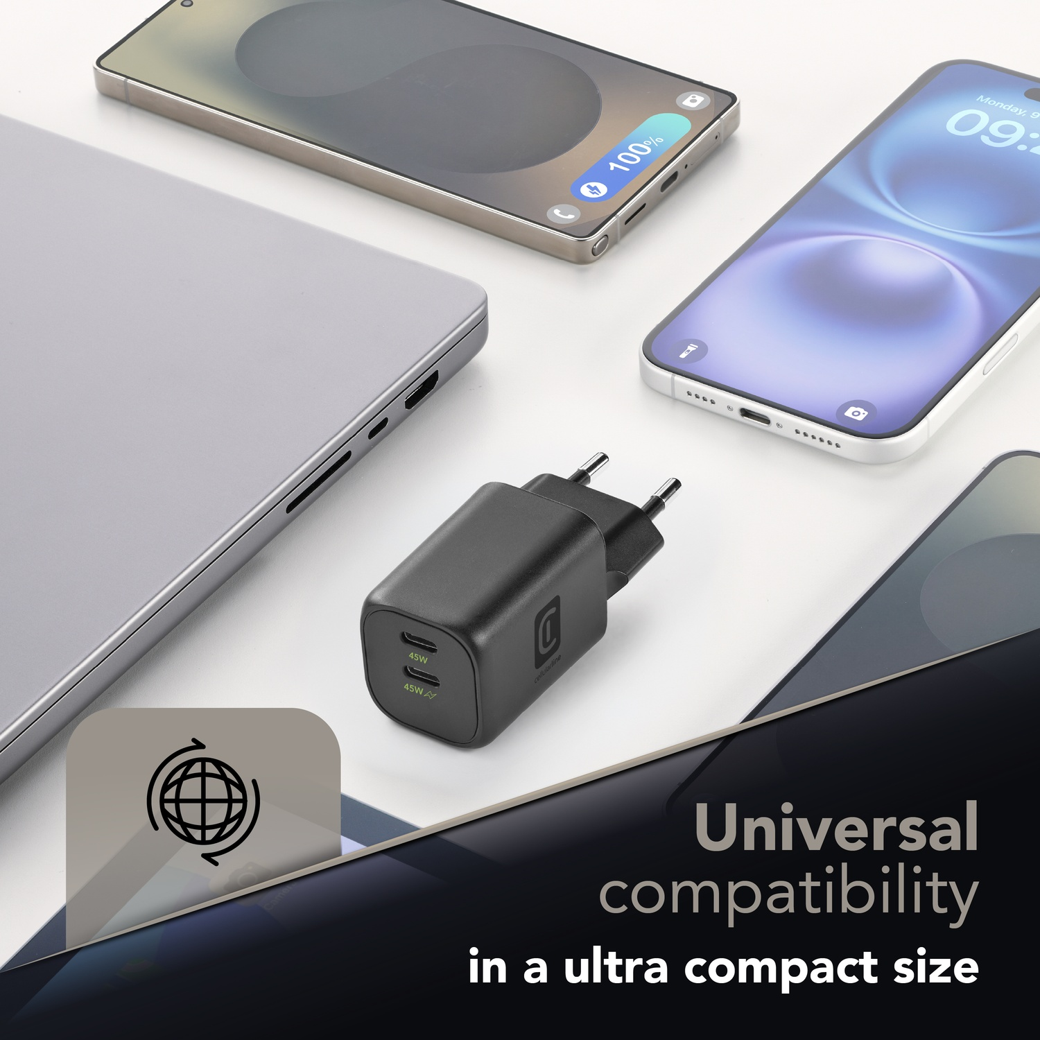 Un caricatore nero con due porte USB-C è posto accanto a laptop e smartphone.