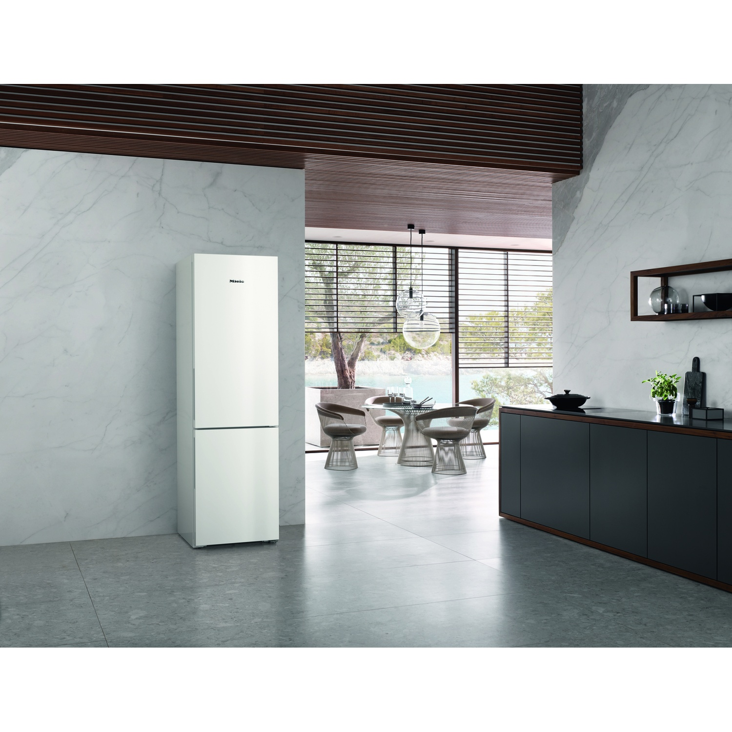 Un frigorifero bianco si trova in una cucina moderna con pareti in marmo e travi di legno.