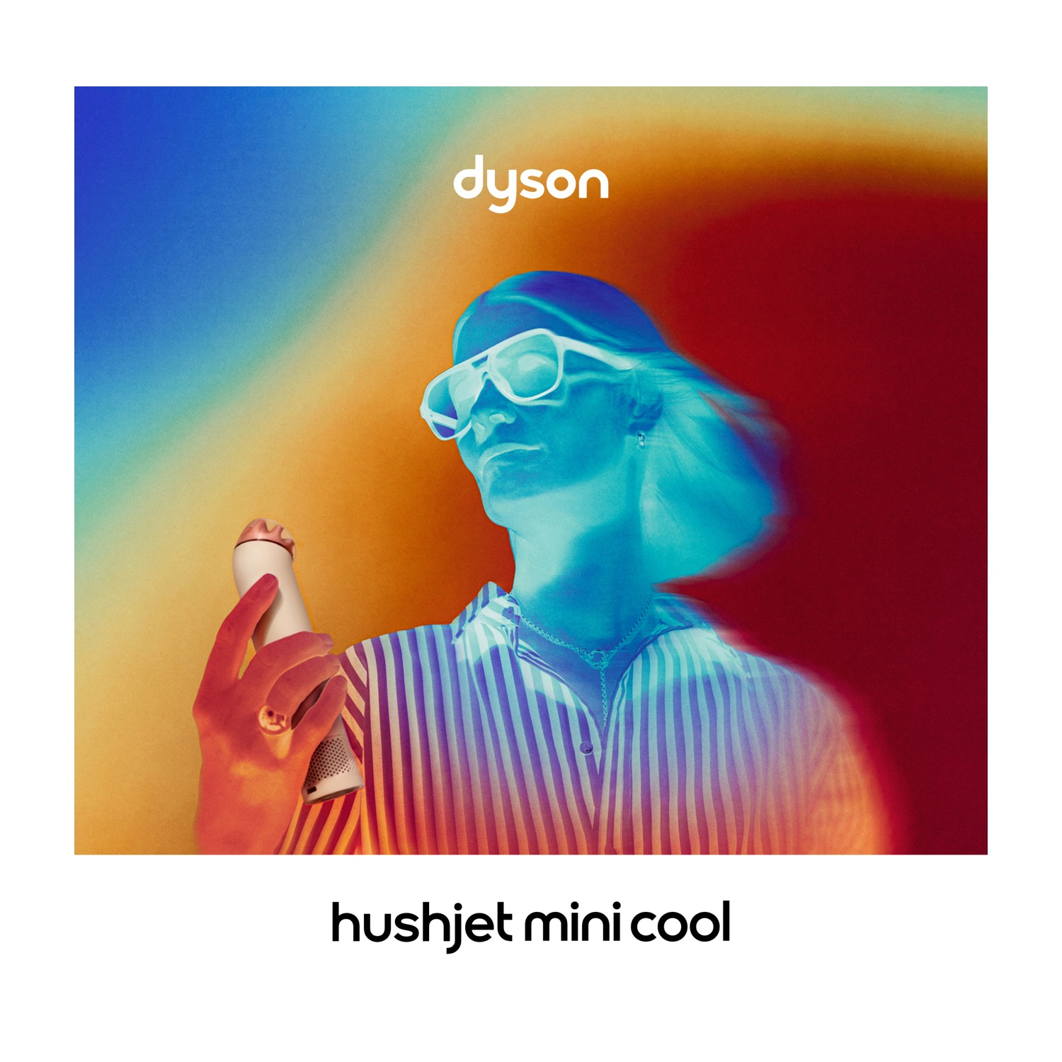 Persona con occhiali da sole tiene dispositivo Dyson su sfondo colorato.