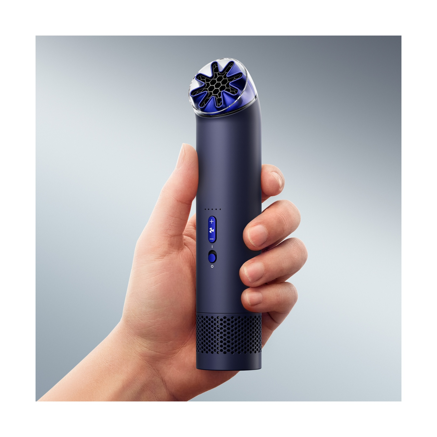 Una mano tiene un dispositivo cilindrico scuro con una griglia blu a forma di stella in cima.