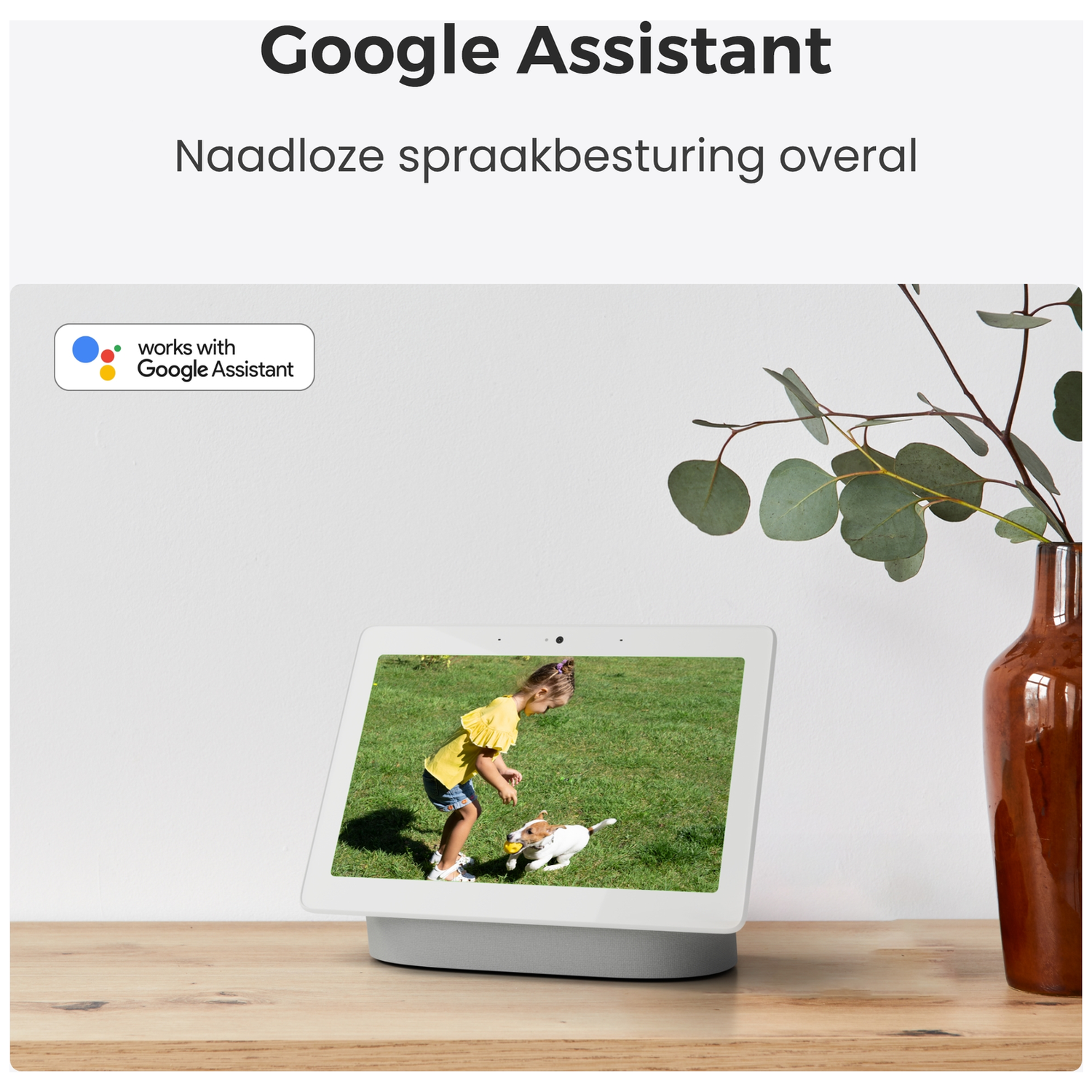 Een Google Nest Hub toont een meisje met hond in de tuin. 'Works with Google Assistant' wordt weergegeven.