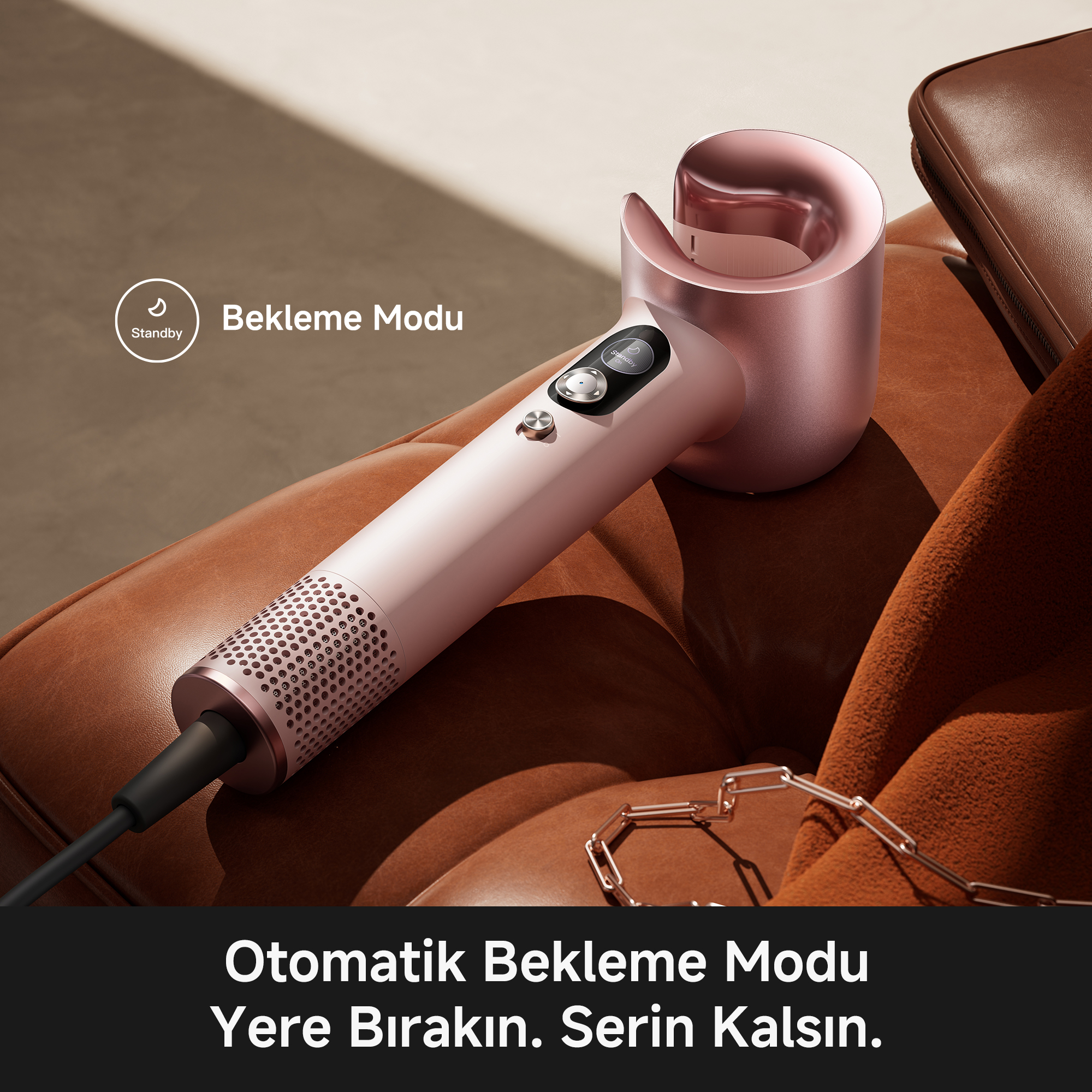 Gül altın rengi saç kurutma makinesi kahverengi deri üzerinde duruyor. "Bekleme" modu.