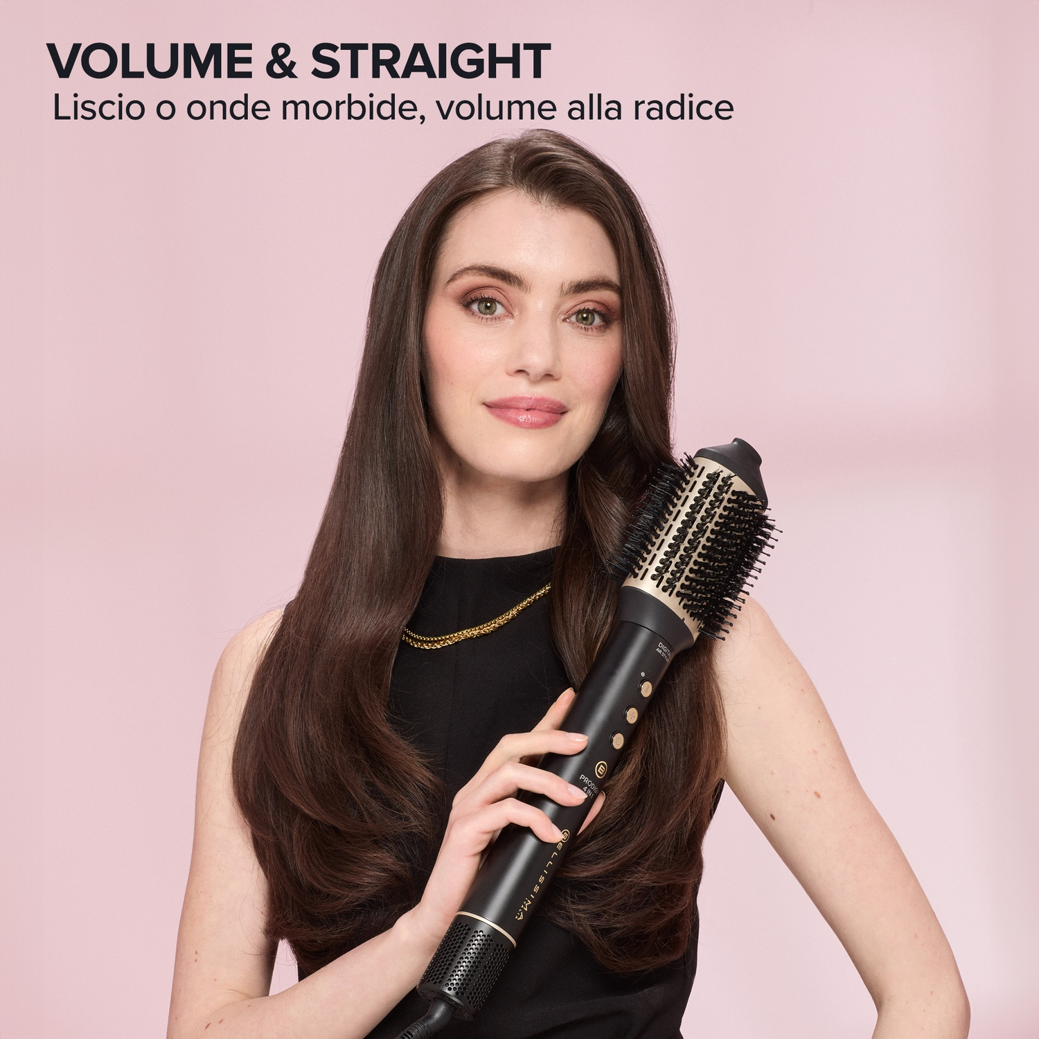 Donna con lunghi capelli castani tiene una spazzola styling nera e oro su sfondo rosa.