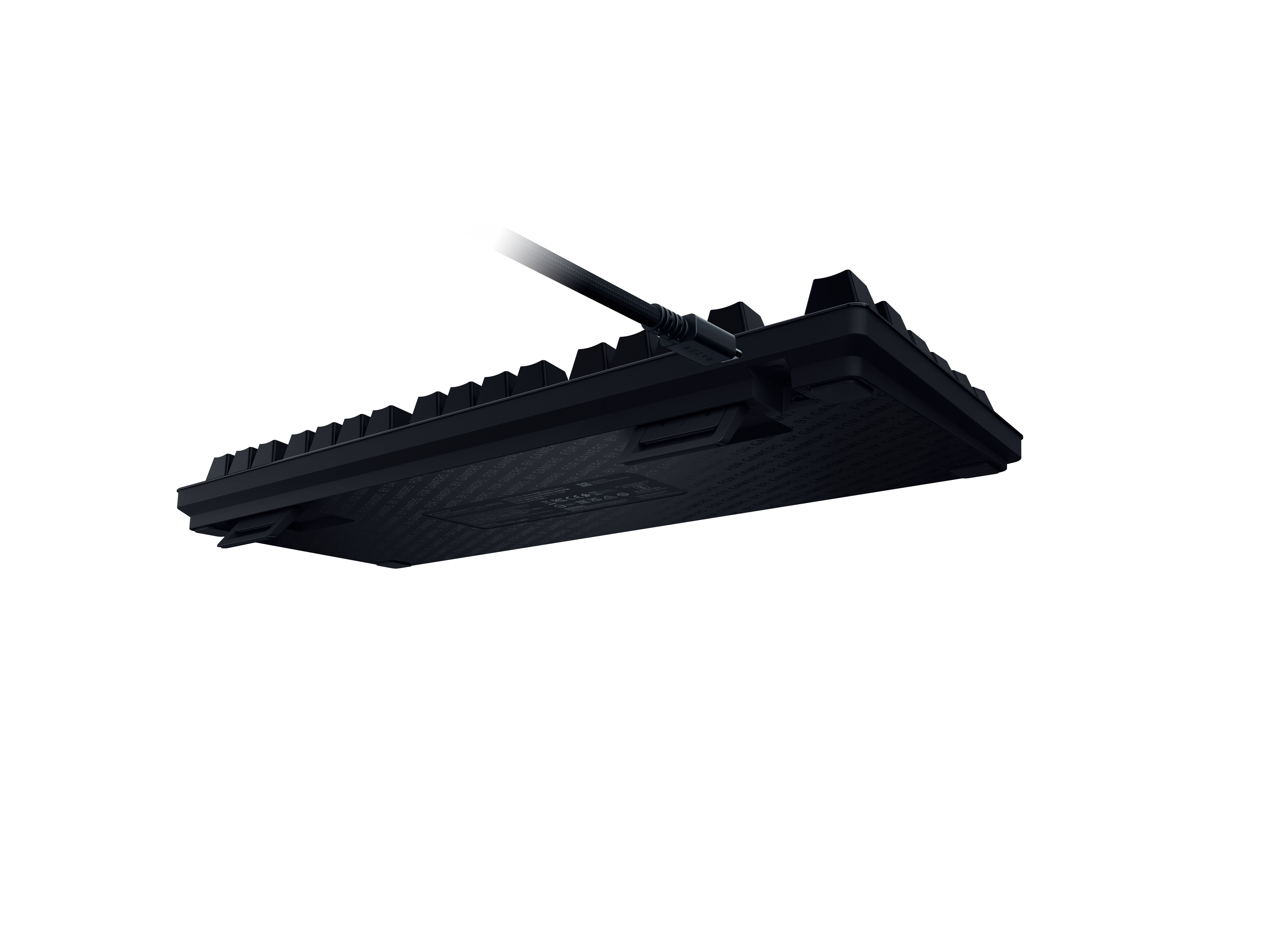 Schwarze Tastatur von unten mit Kabelanschluss, auf weißem Hintergrund.