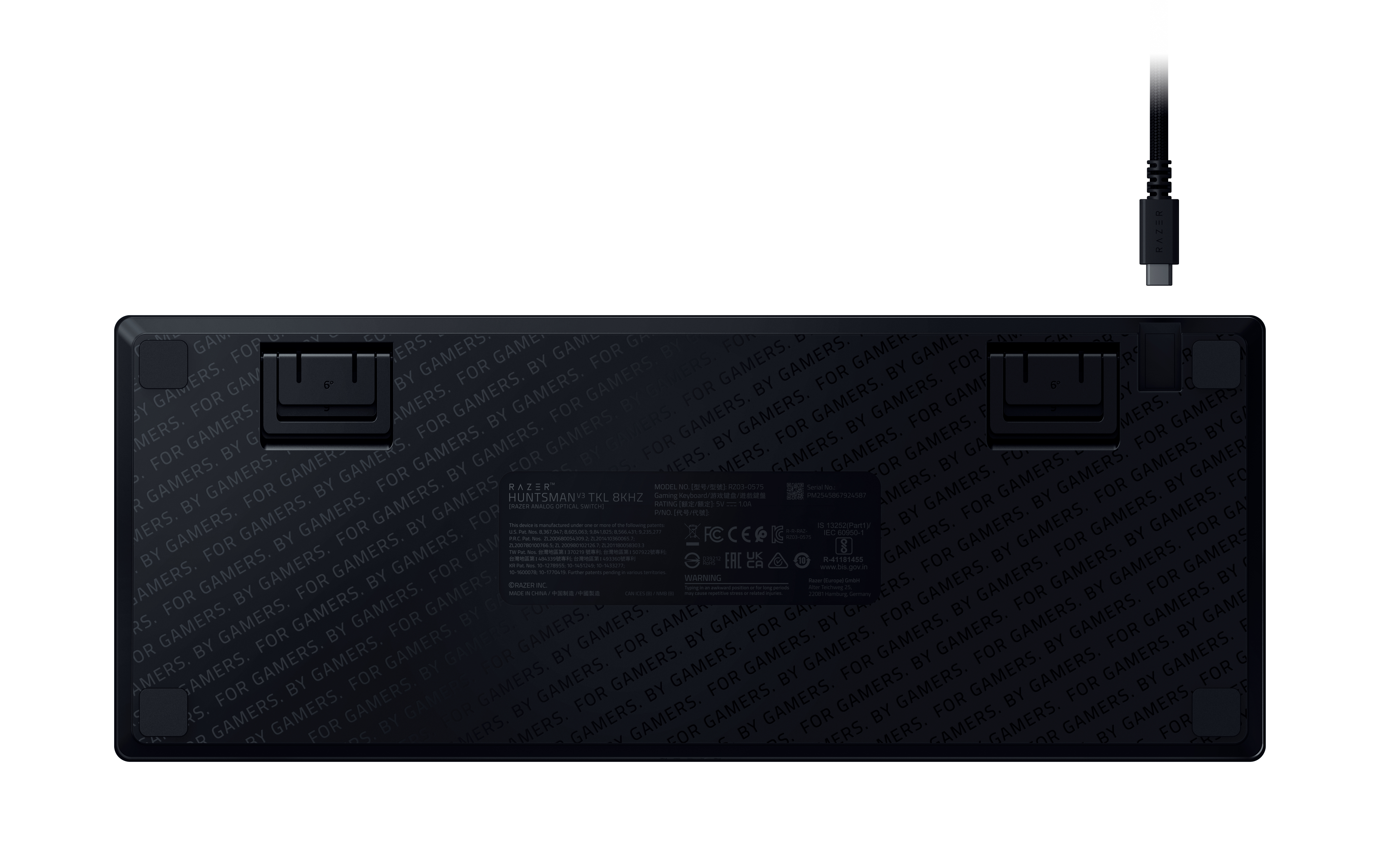 Rückseite einer schwarzen Tastatur mit wiederholtem Muster und USB-C-Kabel.