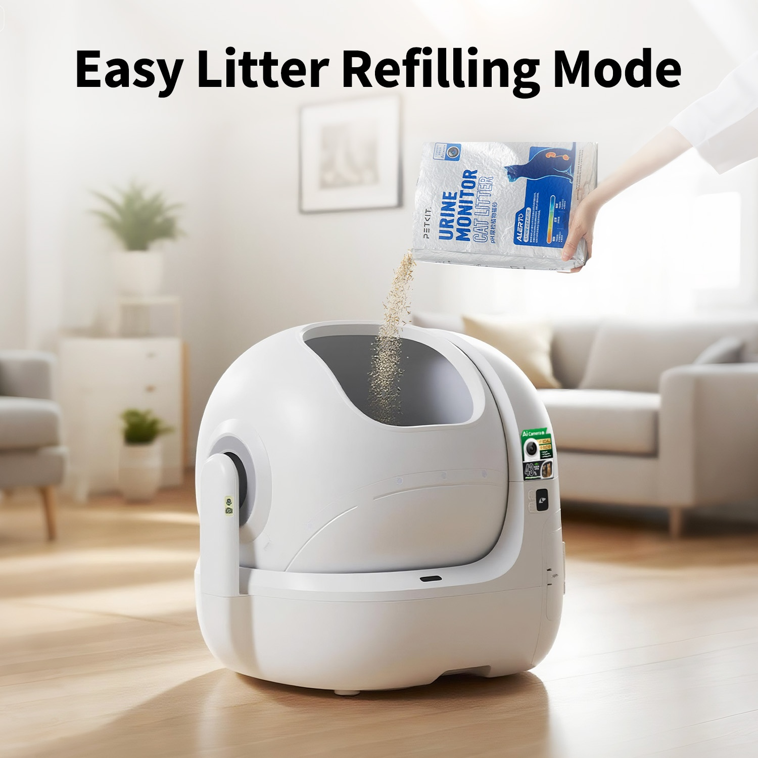 A hand refills a white automatic cat litter box with cat litter.