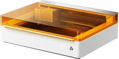Un grabador láser blanco compacto con tapa naranja transparente y cabezal láser visible.