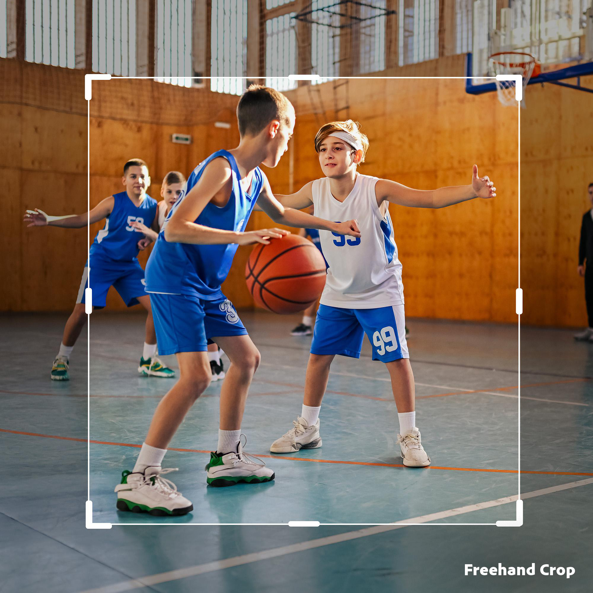 Junge Basketballspieler in blauen Trikots spielen auf einem Hallenplatz.