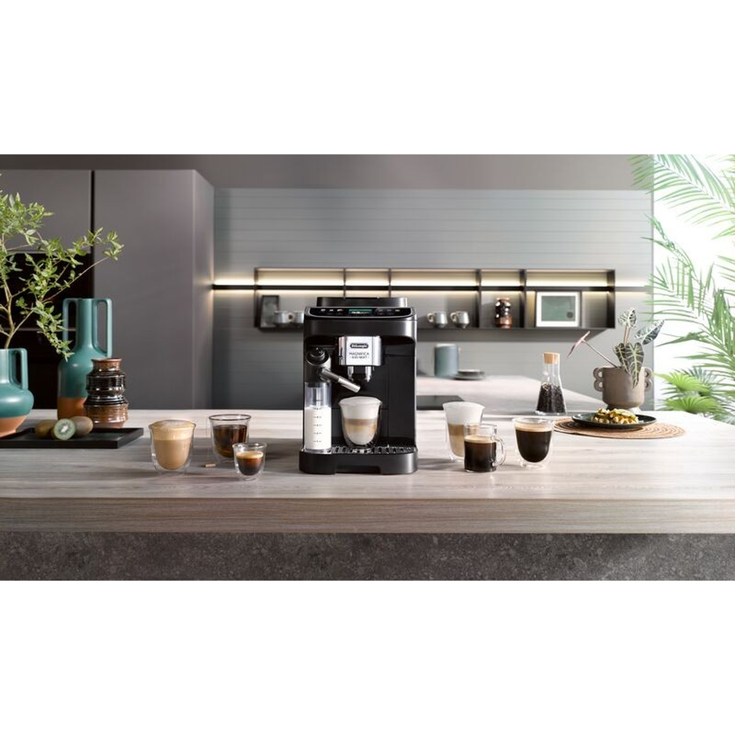 Una macchina da caffè nera prepara il caffè, con bicchieri di caffè e latte nelle vicinanze.